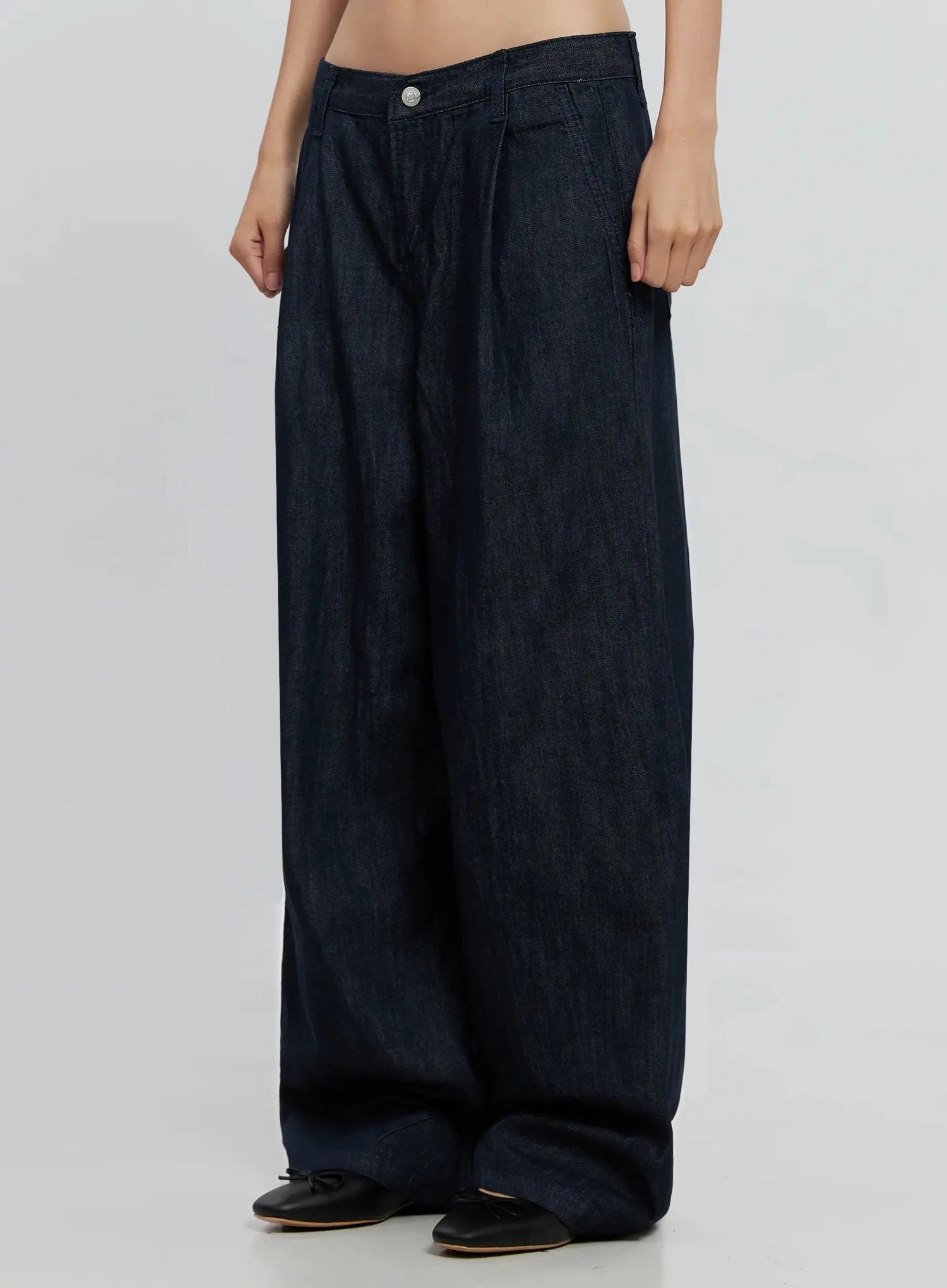 Elio Pintuck Wide-Leg Jeans IS516 in dark indigo, angled front view from waist down, pintuck pleats and voluminous wide leg silhouette highlighted, low-rise waistband detail.