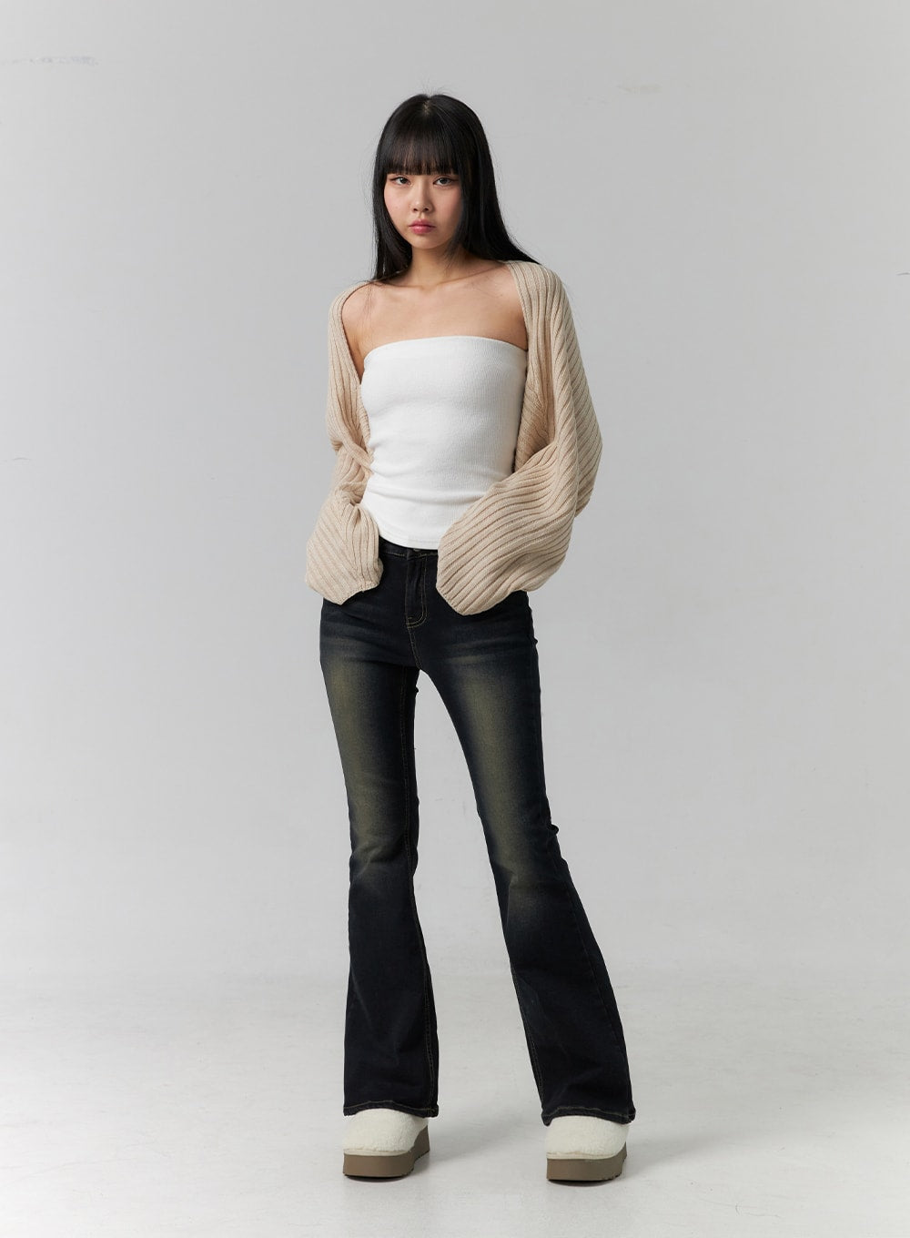 Washed Low Rise Bootcut Jeans CD308 in dark blue, full-length front model shot with hands in pockets, low waist and bootcut hem, styled with white tube top and beige chunky-knit cardigan.