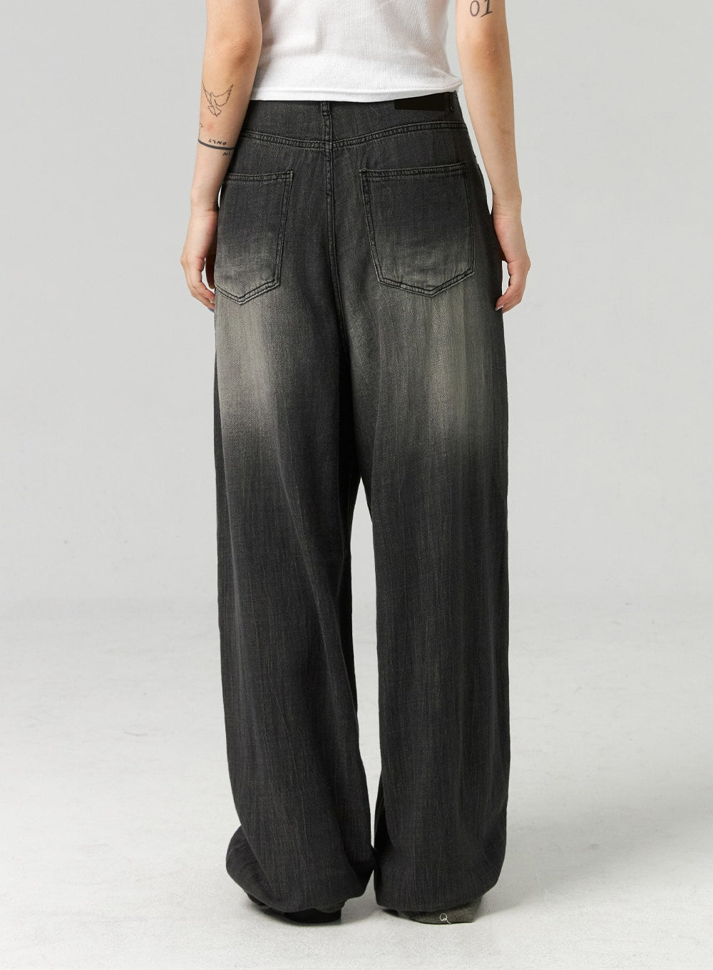 Baggy Jeans CL321 in washed dark grey, back view close-up on model from waist to hem, showing dual back pockets and gradient washed cotton denim, wide relaxed leg.