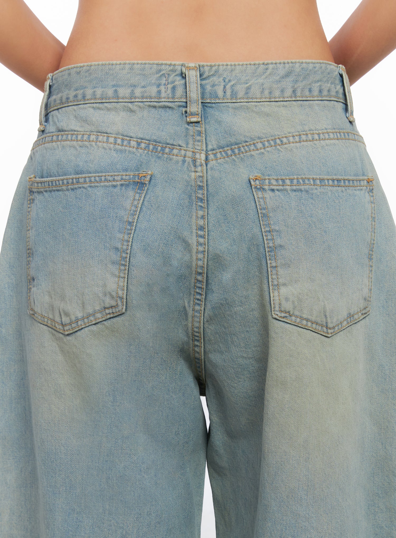 Remi Washed Baggy Jeans CO515 in light blue, back close-up on model, dual back pockets with contrast stitching and sun-faded washed finish on cotton denim.