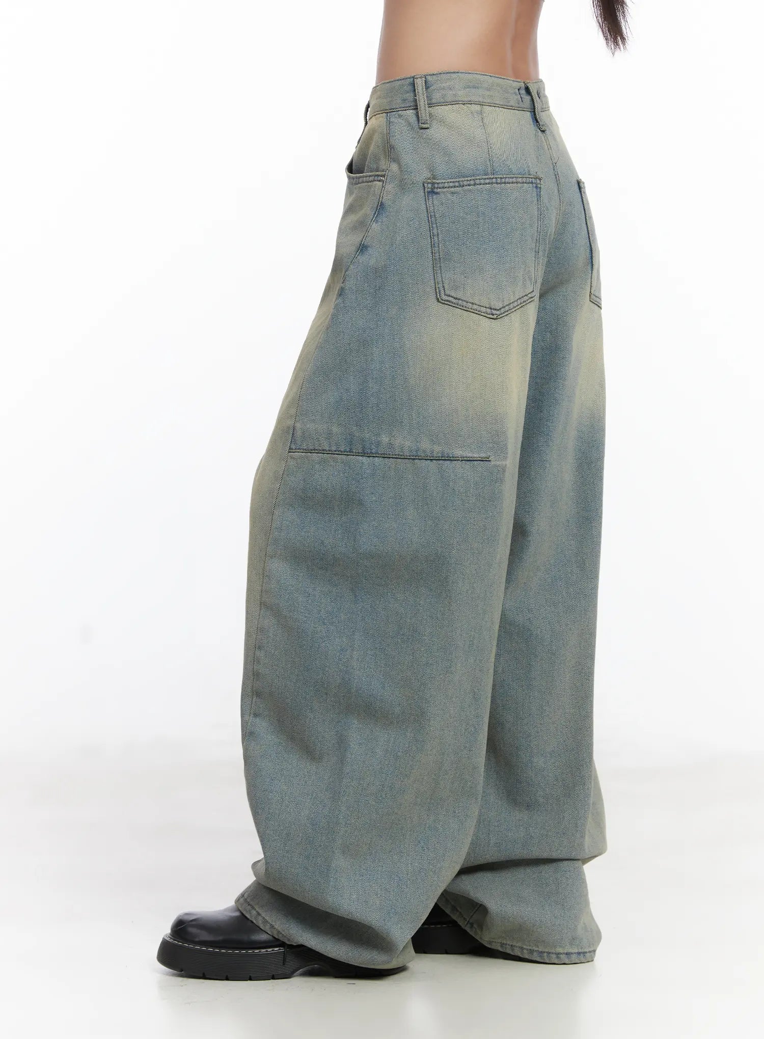 Lyla Washed Wide Leg Jeans CD530 in light blue, side close-up on model from waist to hem, showing large patch back pocket, panel seam, and vintage yellow-tinted washed denim texture.