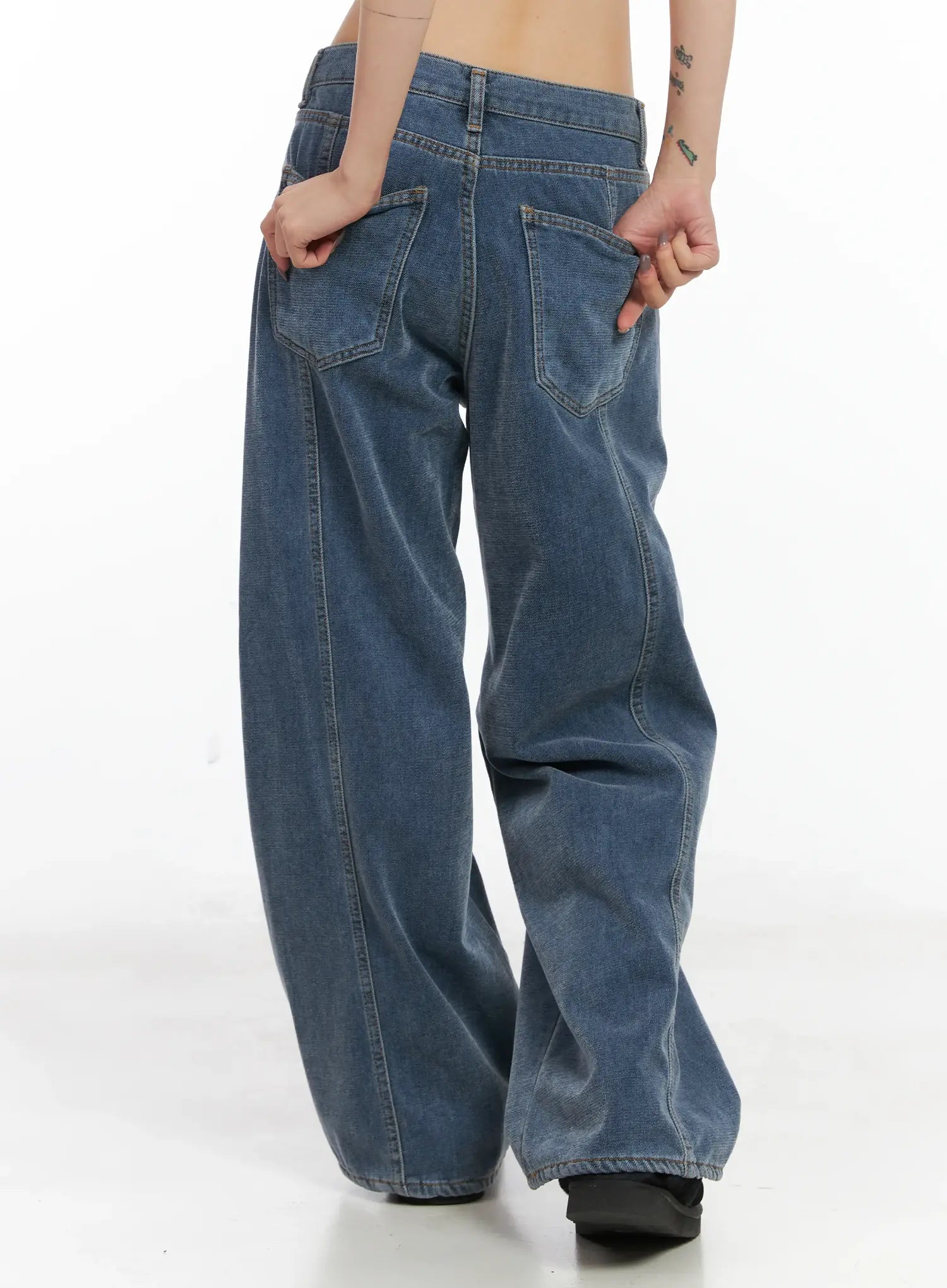 Norah Oversized Jeans CN528 in blue, back close-up on model showing angled back pockets, contrast stitching, and wide-leg washed denim volume.