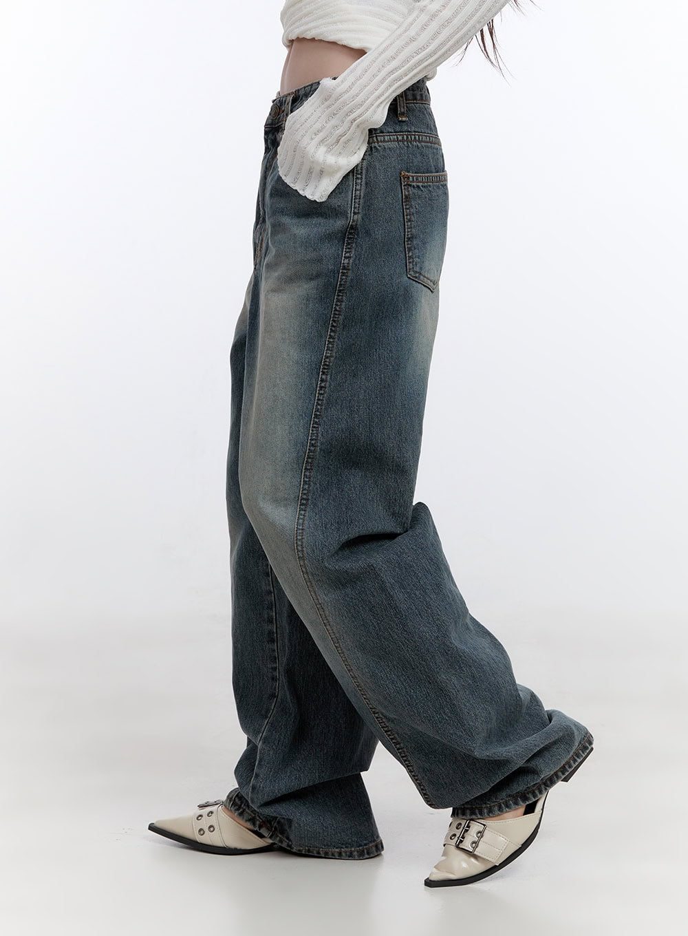 Lucia Stitched Denim Baggy Jeans CO418 in blue, side close-up on model mid-stride, highlighting curved panel stitching, wide leg hem pooling at ankle, and side pocket detail.