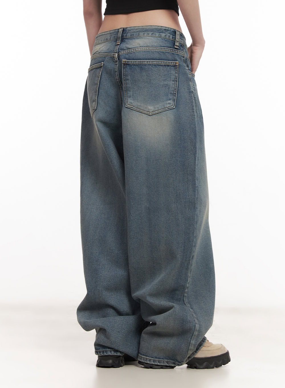 Shelly Washed Baggy Jeans CM518 in blue, back side view on model, rear patch pockets with washed toning, voluminous baggy leg pooling at hem, paired with black crop top.