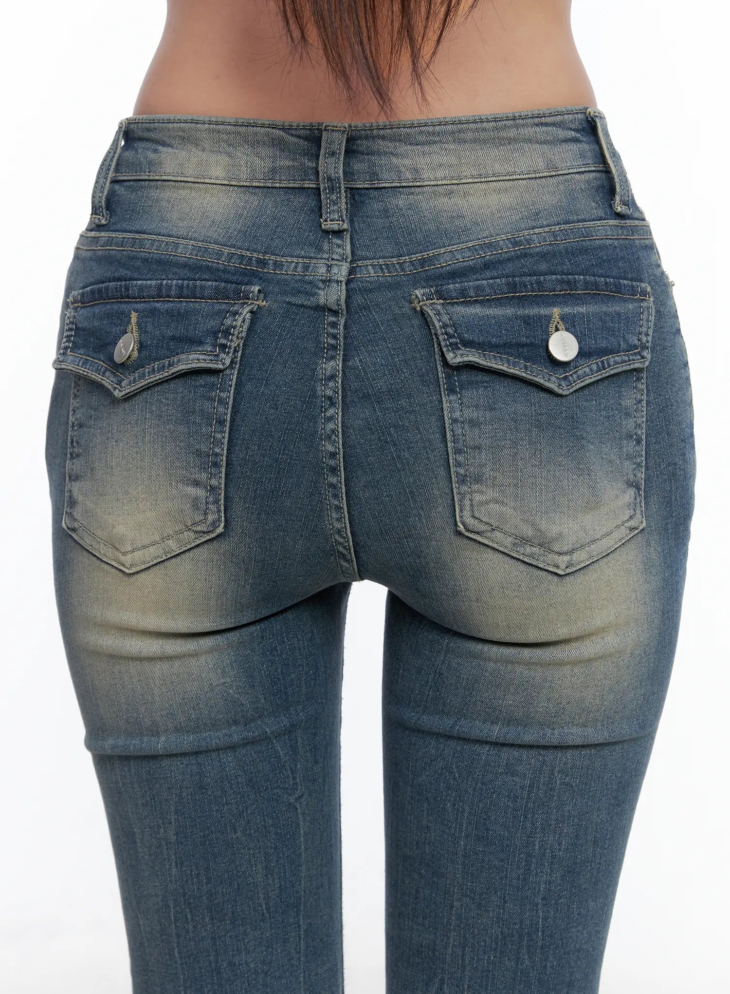 Sloan Vintage Hip Pad Flare Jeans CS502 in dark blue, close-up back detail shot, dual flap back pockets with silver charm buttons, vintage yellow-tinted fade on seat.