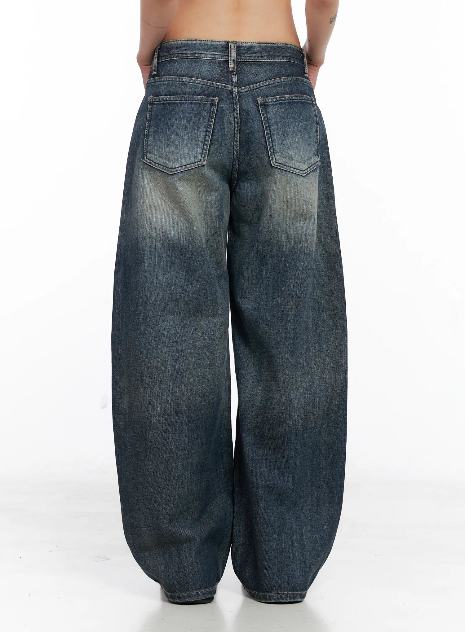 Nellie Baggy Jeans CS526 in blue, back close-up on model, featuring two large back pockets with stitched detail, washed indigo denim, and rounded wide-leg hem.