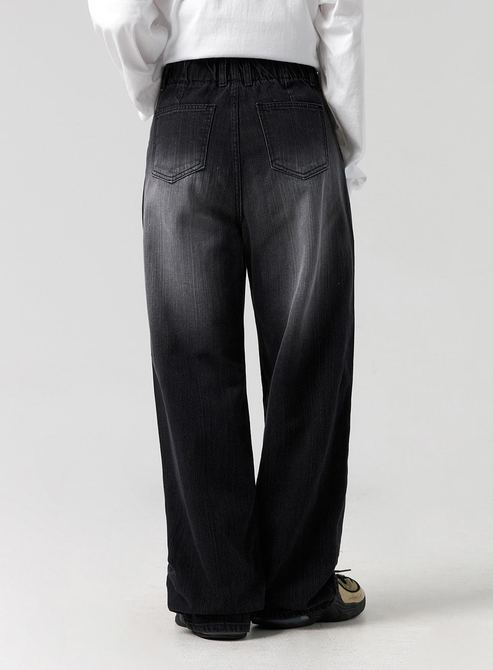 Washed Wide-Leg Jeans CG327 in black, back view close-up on model from waist to hem, elastic waistband detail, dual back pockets, washed denim with wide-leg silhouette, paired with white top.