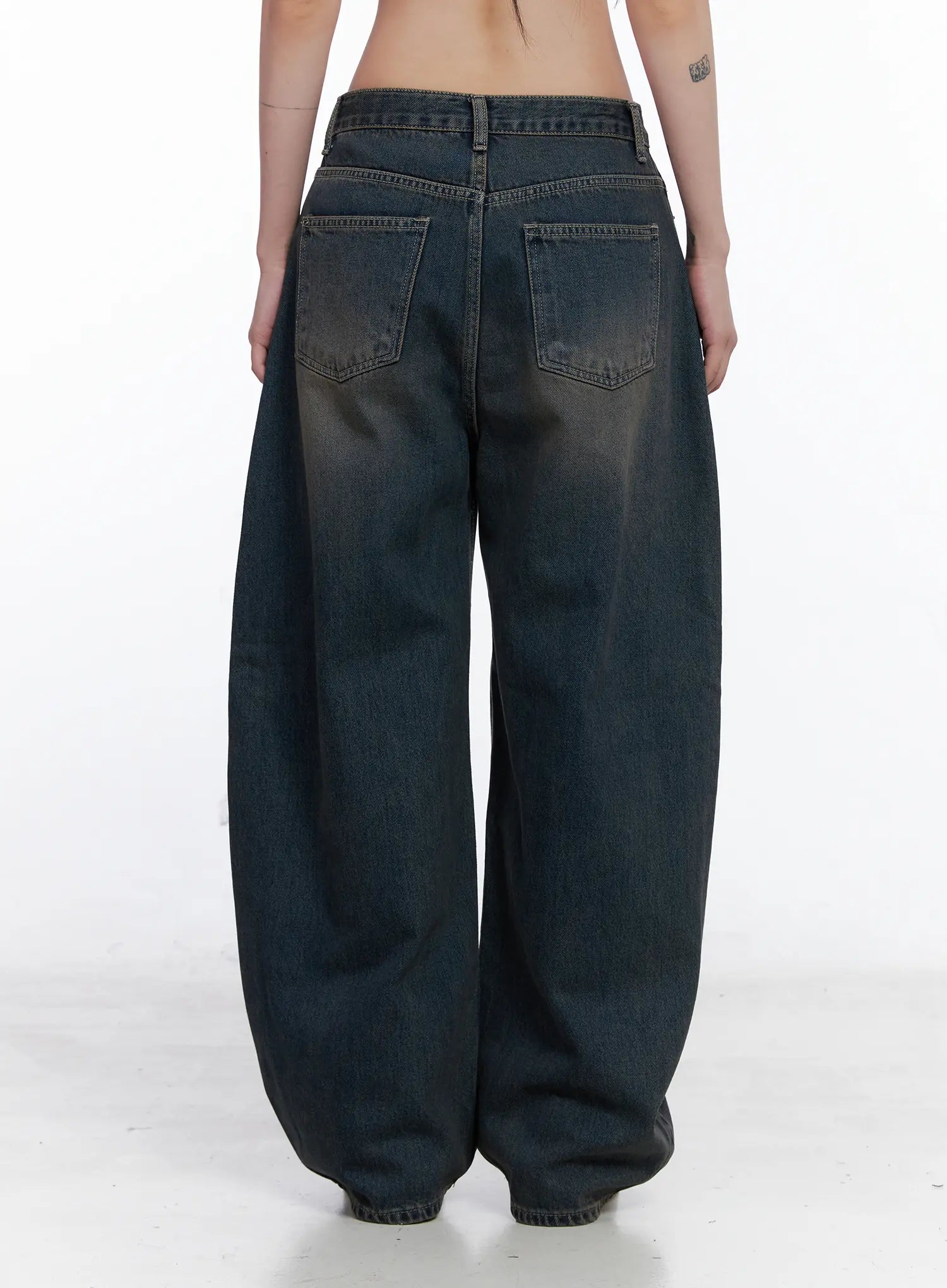 Ocean Faded Balloon Fit Jeans CS510 in washed dark indigo, back close-up on model, rear patch pockets and balloon-volume leg silhouette with faded wash detail visible.