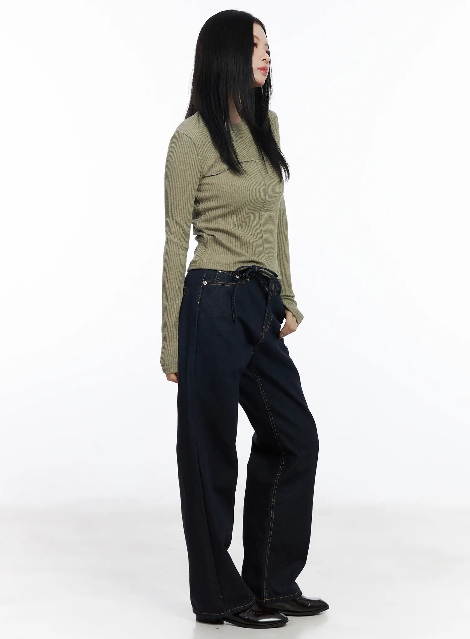 Mingi Non-Fade Semi-Wide Belted Jeans CJ519 in dark blue, side styling shot on model, tie belt detail at waist, wide-leg drape, paired with sage ribbed top and black loafers.