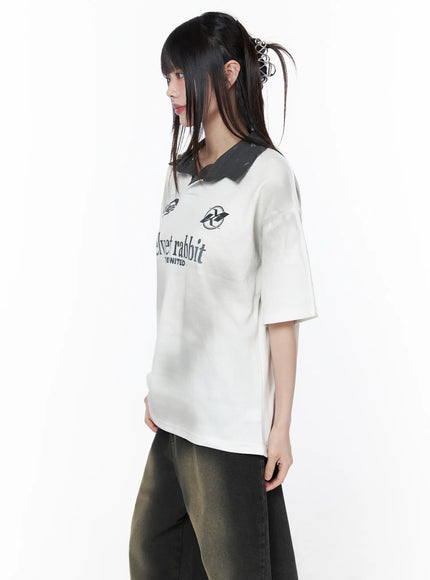 Oversized Collar Jersey CU519 in white, side close-up on model, contrast ribbed dark polo collar and graphic logo print visible, oversized boxy short sleeve jersey, paired with dark wide-leg jeans.