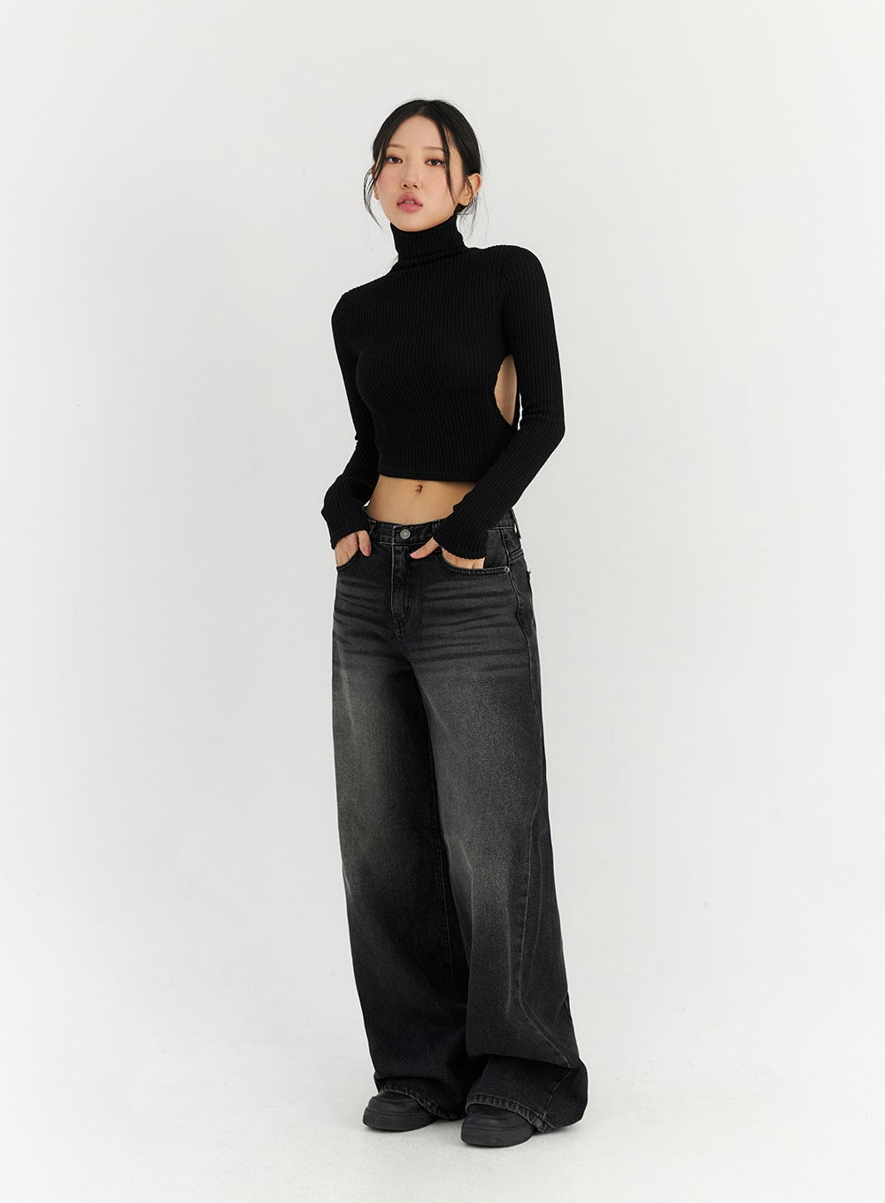 Back Slit Washed Wide Leg Jeans CN306 in Black, three-quarter front view on model, hands in pockets, low-waist washed wide leg denim, street style look with cropped ribbed turtleneck.