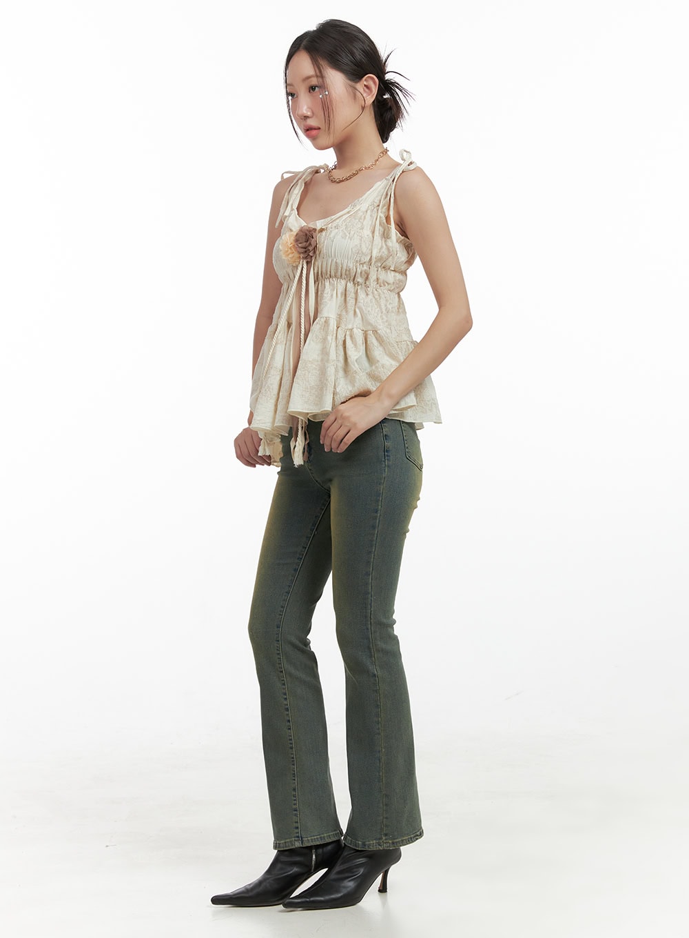 Pamela Belt Bootcut Jeans OG407 in Yellow, three-quarter side view on model standing, washed green-yellow bootcut denim with slim fit and gentle flare hem, paired with cream cami.