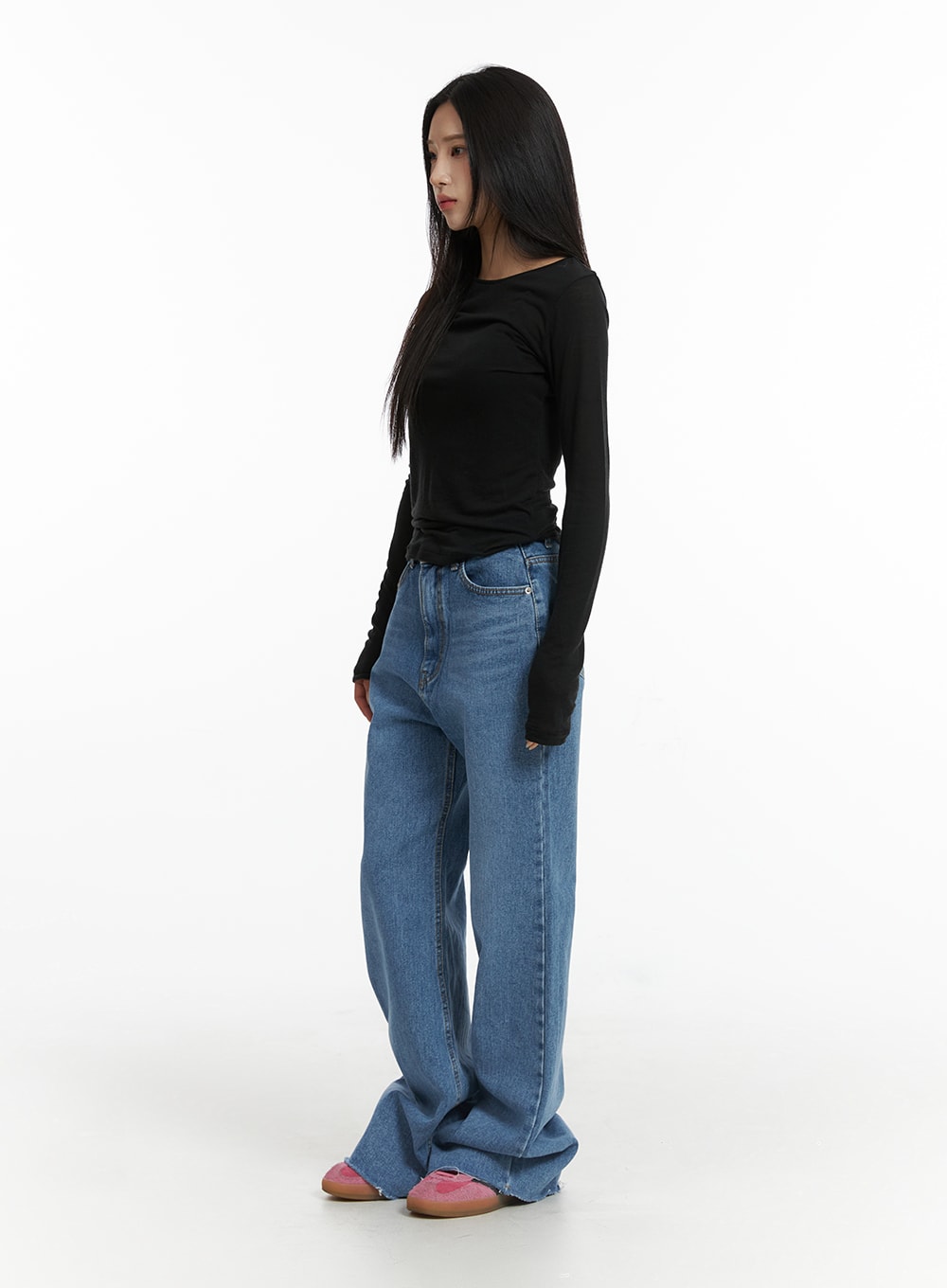 Blue Denim Bootcut Jeans CJ431 in blue, three-quarter side shot on model, showing slim fit through thigh flaring to wide bootcut, washed denim with raw hem, paired with black long sleeve top.