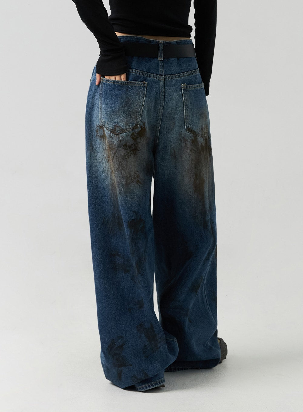 Street-Style Wide Fit Washed Jeans CO323 in Blue, back view waist-to-hem on model, showing dual back pockets and heavy brown washed stain pattern on wide leg cotton denim.