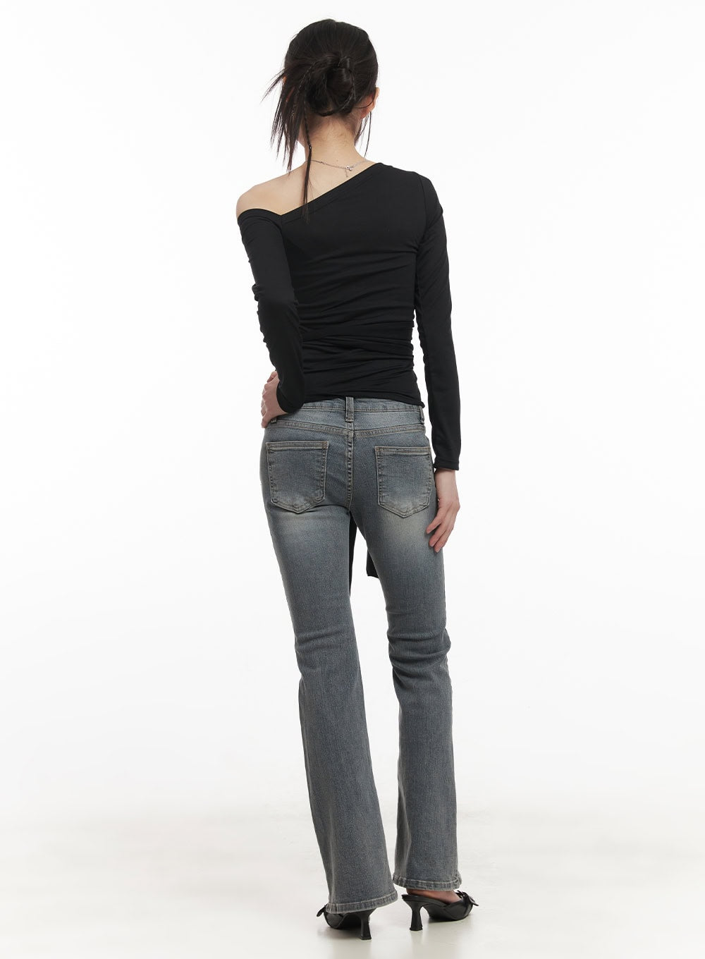 Rachel Washed Bootcut Jeans with Hip Pads CF518 in gray, full-body back shot on model, low-waist bootcut flare with washed finish, styled with black off-shoulder top and heels.