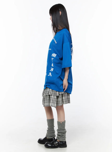 Plaid Layered Midi Skirt CU519 in black, side profile full-length shot on model, tiered ruffle silhouette visible under oversized blue tee, grey leg warmers and buckle loafers.