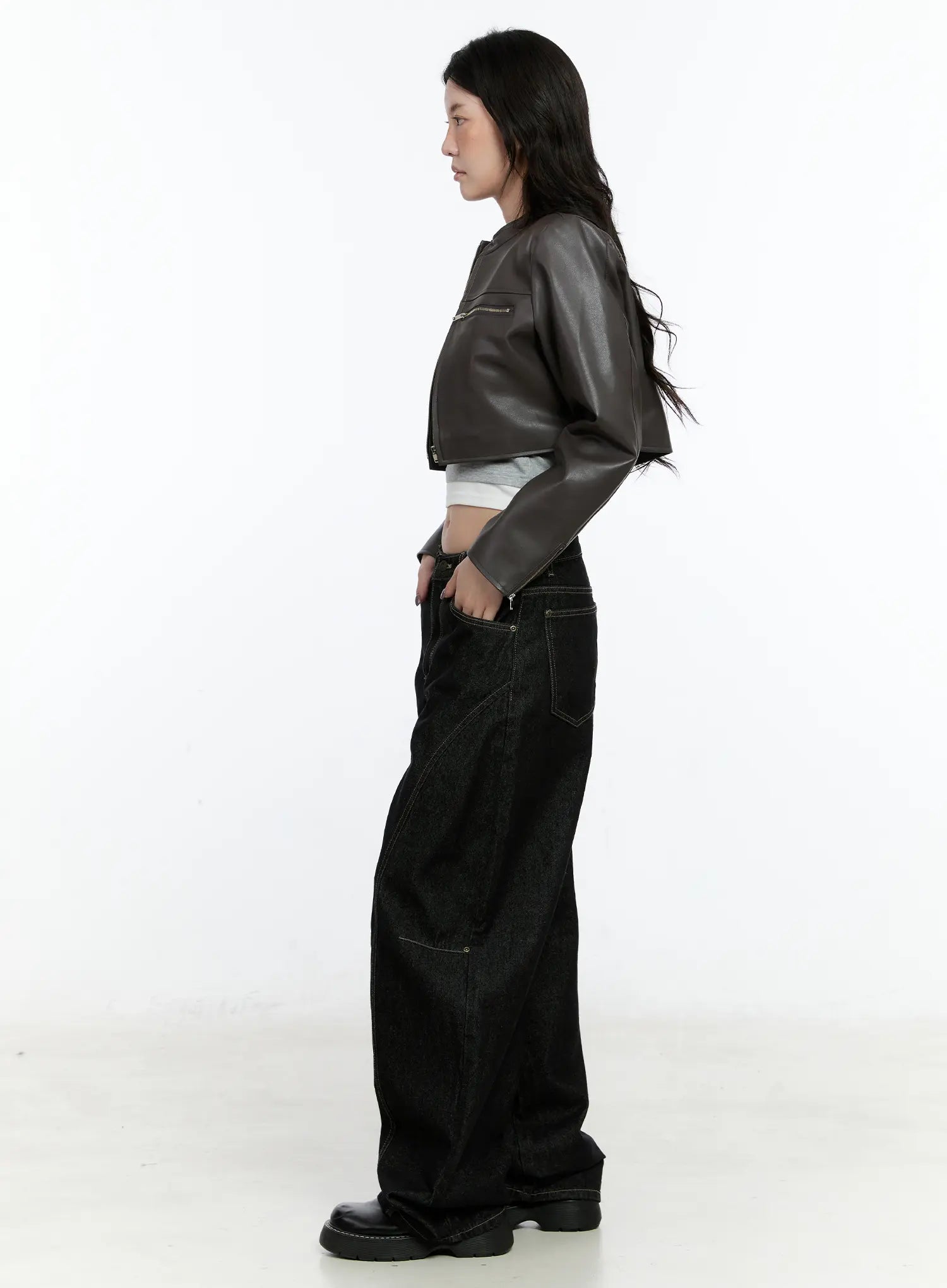 Maryam Low-Rise Dark-Washed Jeans CN517 in black, side view on model wearing brown cropped jacket, wide-leg silhouette with contrast stitching visible, long length, black loafers.