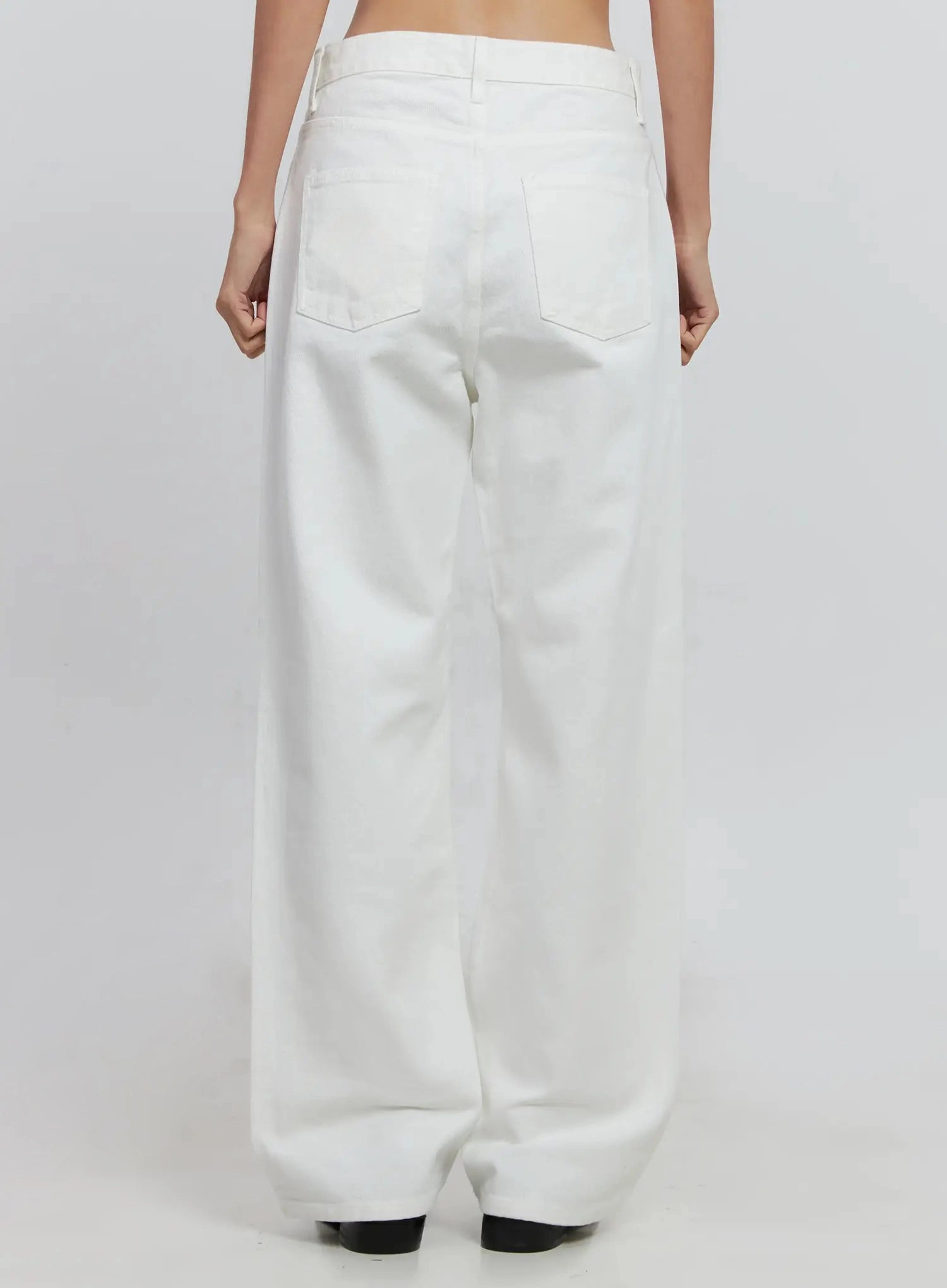 Taytum Straight-Leg Jeans IS515 in white, back full-length view on model, straight-leg cotton denim with two patch back pockets and belt loops, paired with black loafers.