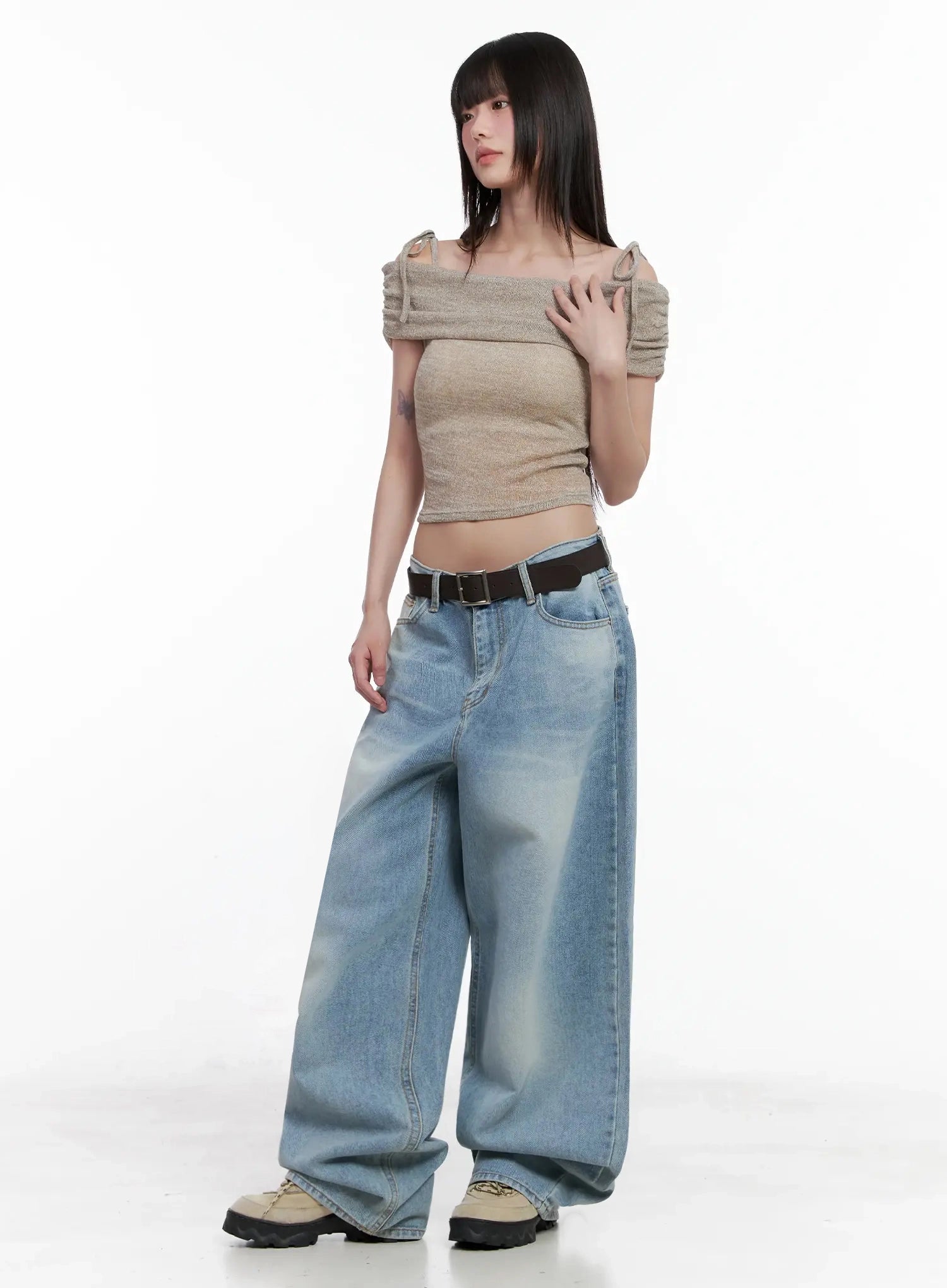 Dain Washed Wide-Leg Jeans IL531 in light blue, angled full-length shot on model looking aside, voluminous wide leg with two-tone wash effect, belted with beige knit top.