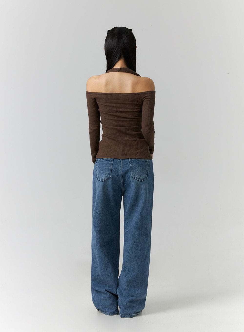 Wide Leg Jeans J12 in blue, full-length back view on model, wide-fit cotton denim with gradation wash, two back pockets visible, floor-length hem, paired with brown off-shoulder top.