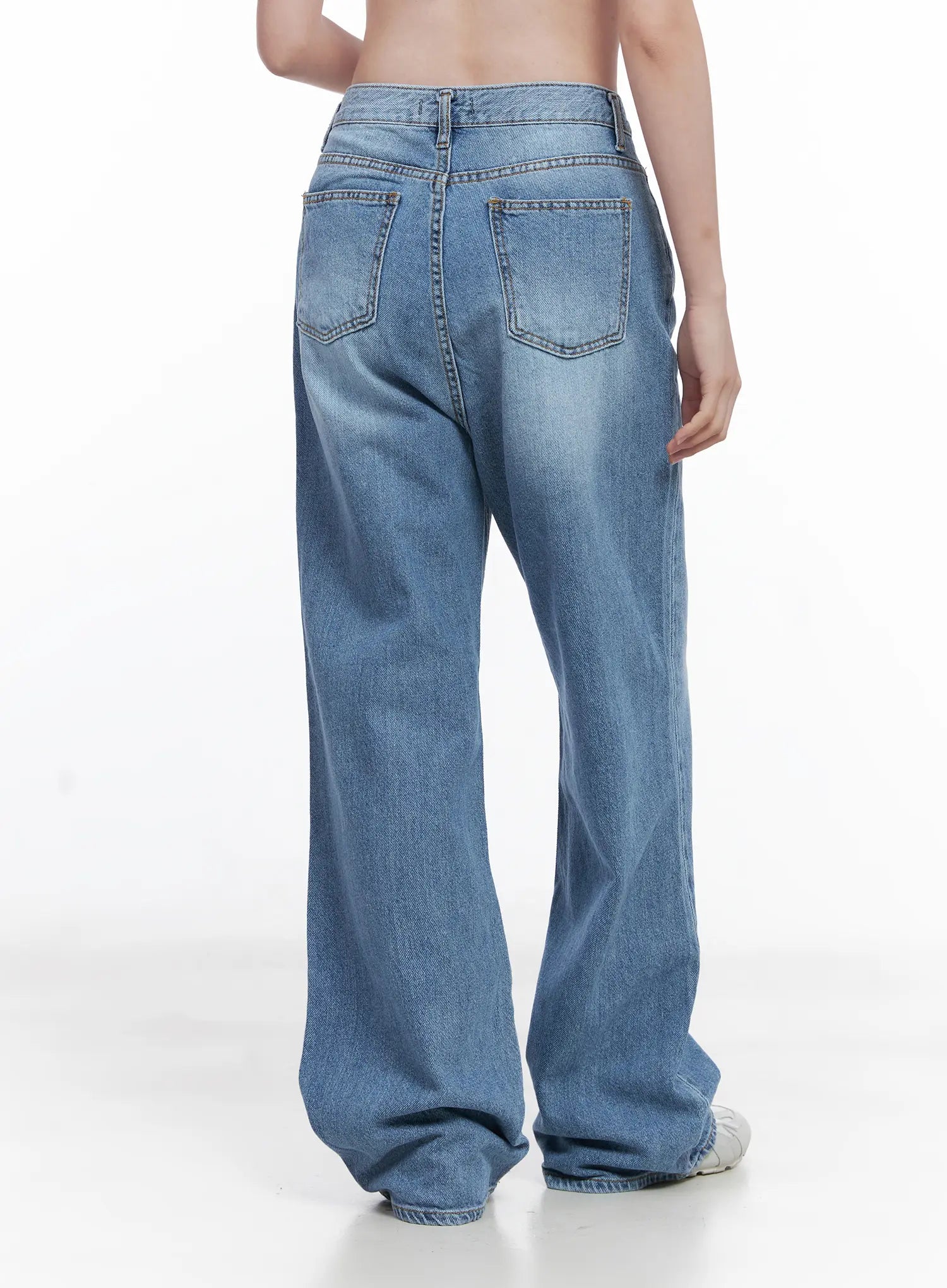 Jung Straight-Leg Washed Jeans CG521 in blue, back view on model, showing two back patch pockets with contrast stitching, high waist, and wide-leg washed cotton denim silhouette.