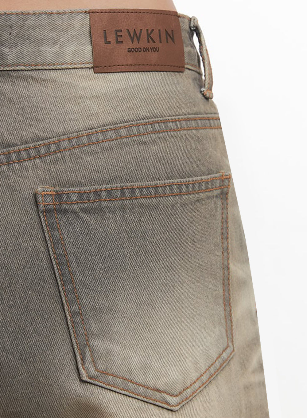Sherry Washed Slim-Fit Bootcut Jeans IM528 in vintage brown, close-up of back pocket and waistband label, showing LEWKIN leather patch, orange topstitching, and washed denim surface detail.