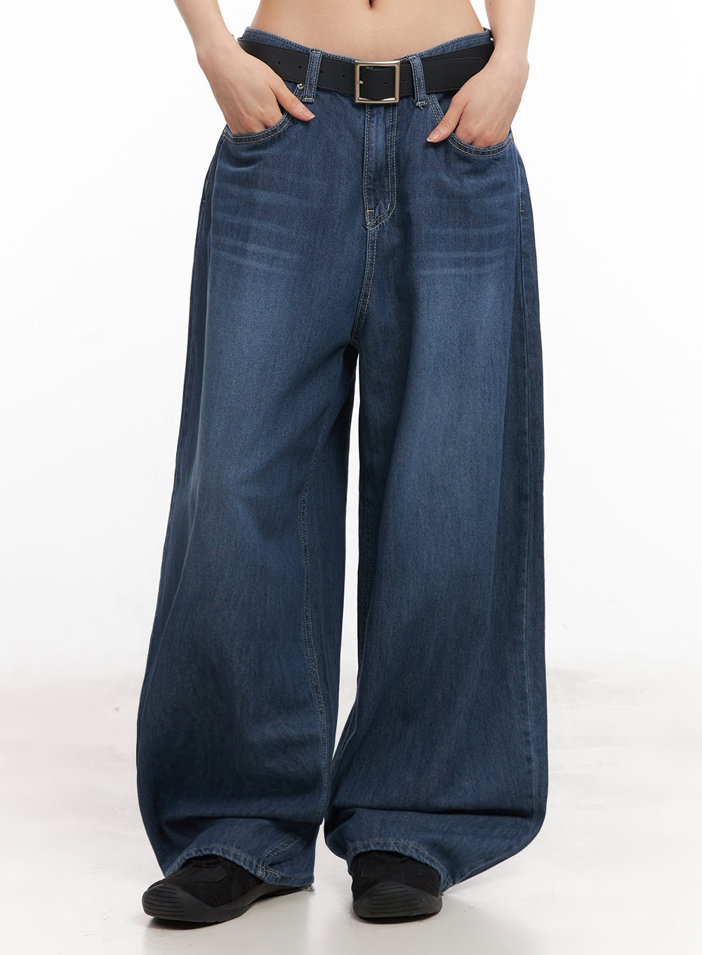 Martha Baggy Jeans IY529 in dark blue, front mid-body shot on model hands in pockets, ultra-wide washed denim leg silhouette with black belt and black sneakers at hem.