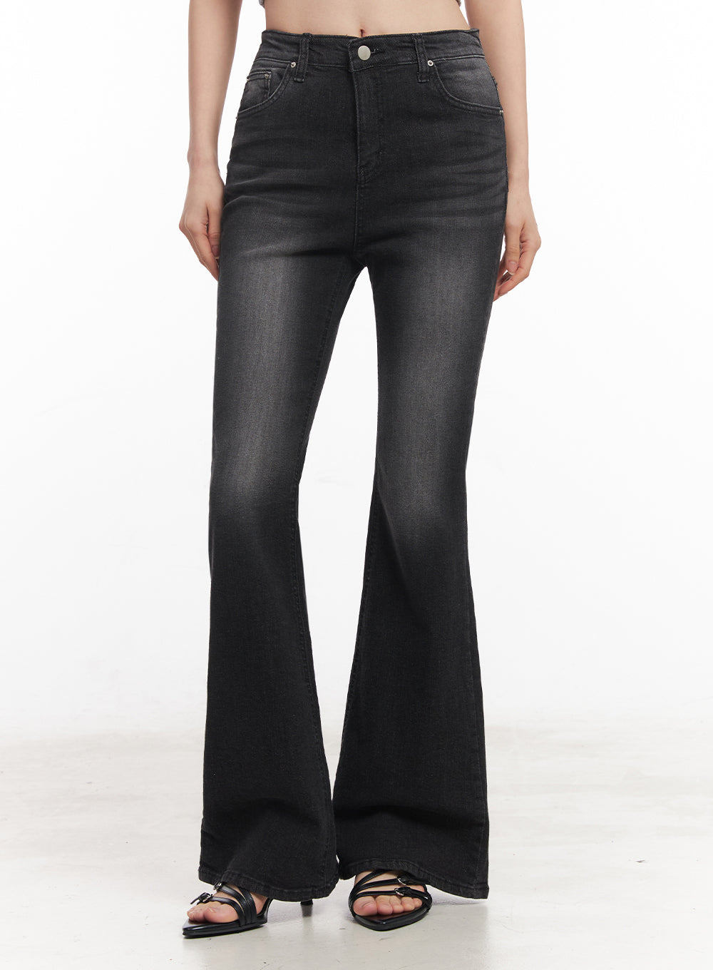 Lior Slim-Fit Bootcut Jeans IY516 in black, front lower-body shot on model, darker washed high-rise bootcut denim, slim thigh with flared hem, silver button detail, black strappy heeled sandals.
