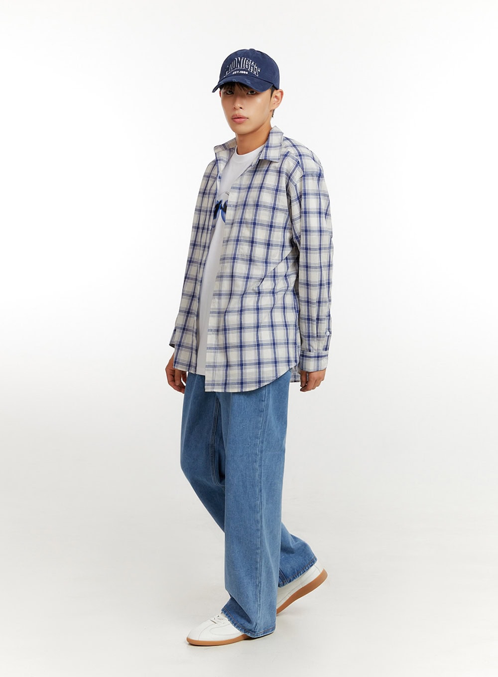 Men's Baggy Jeans (Blue) IU427 in blue, three-quarter side angle on model, baggy wide-leg fit visible, styled with plaid overshirt and cap, casual street look.