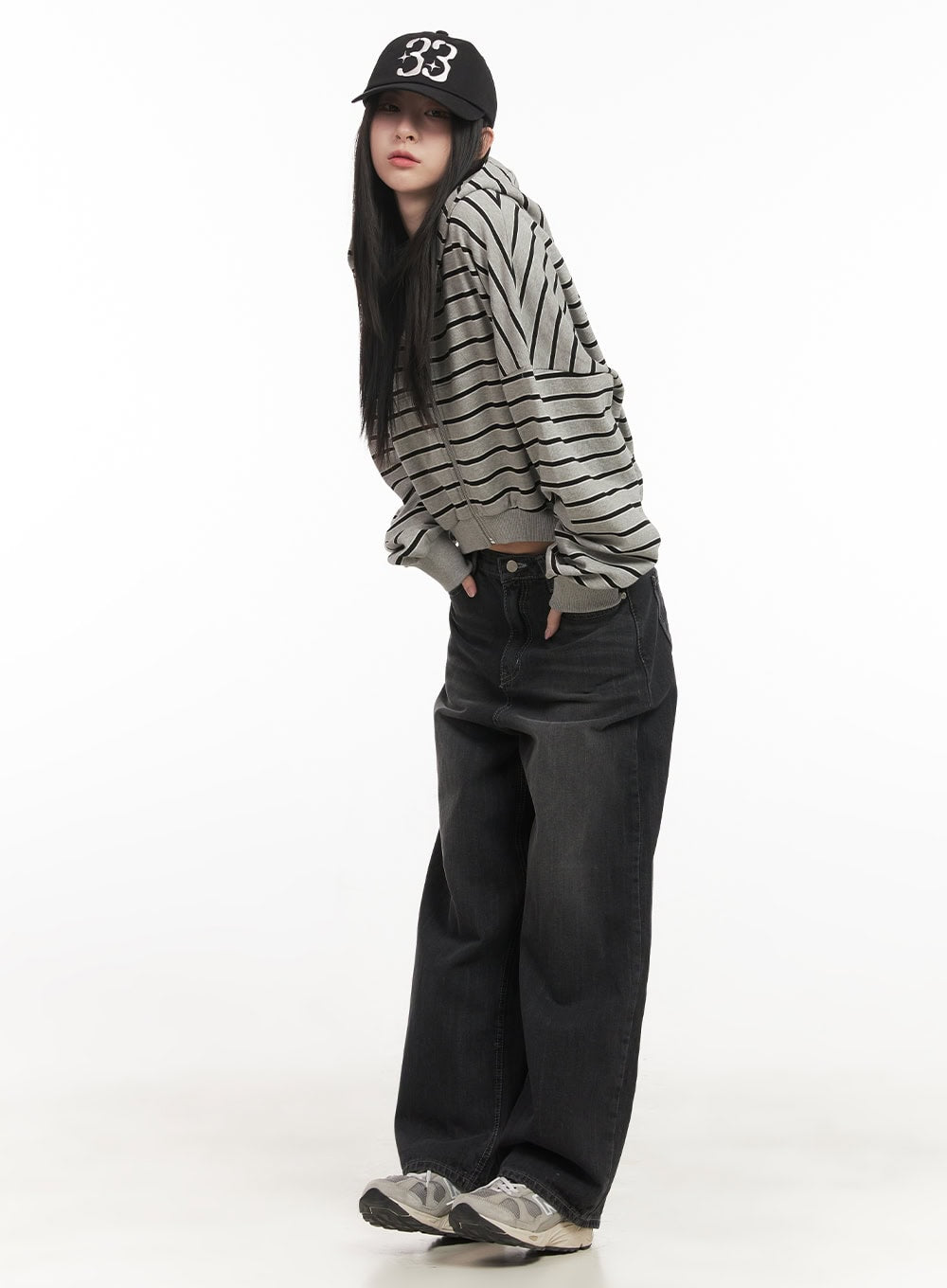 Ruth Washed Wide-Leg Jeans CF514 in black, angled side full-body view on model, relaxed wide-leg fit, styled with grey striped crop hoodie and black baseball cap.
