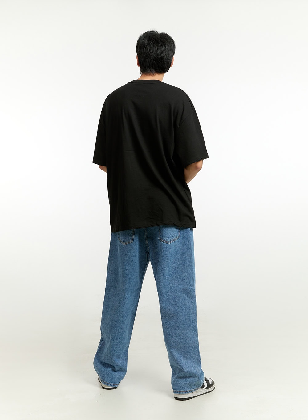 Men's Wide Fit Jeans IL412 in blue, full back view on model, wide-leg silhouette with dual back pockets visible, medium-wash denim, styled with black tee.