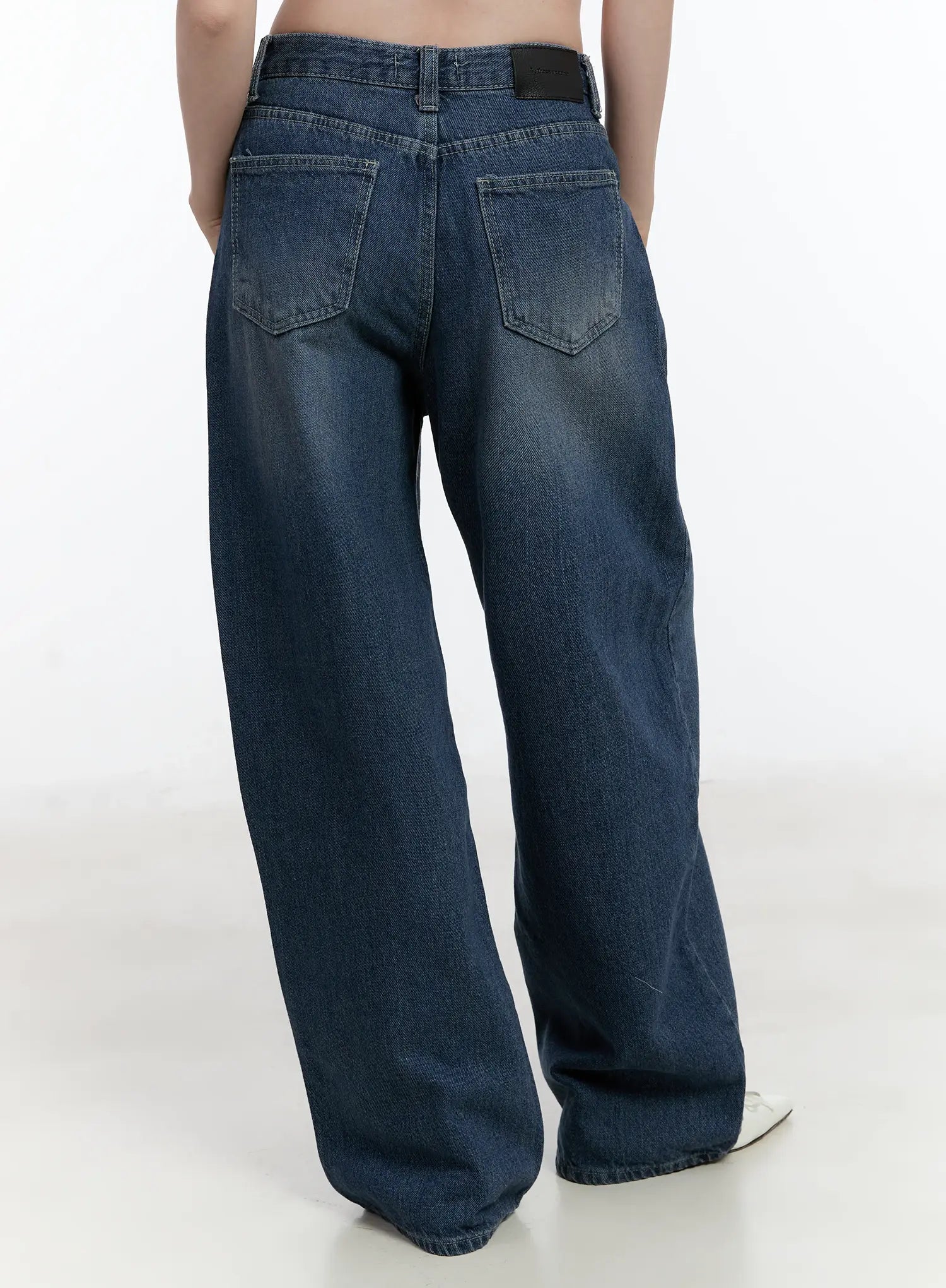 Della Casual Denim Wide Jeans ID511 in blue, back crop shot on model, washed cotton wide-leg denim, dual back pockets and leather brand patch at waistband visible, long length.
