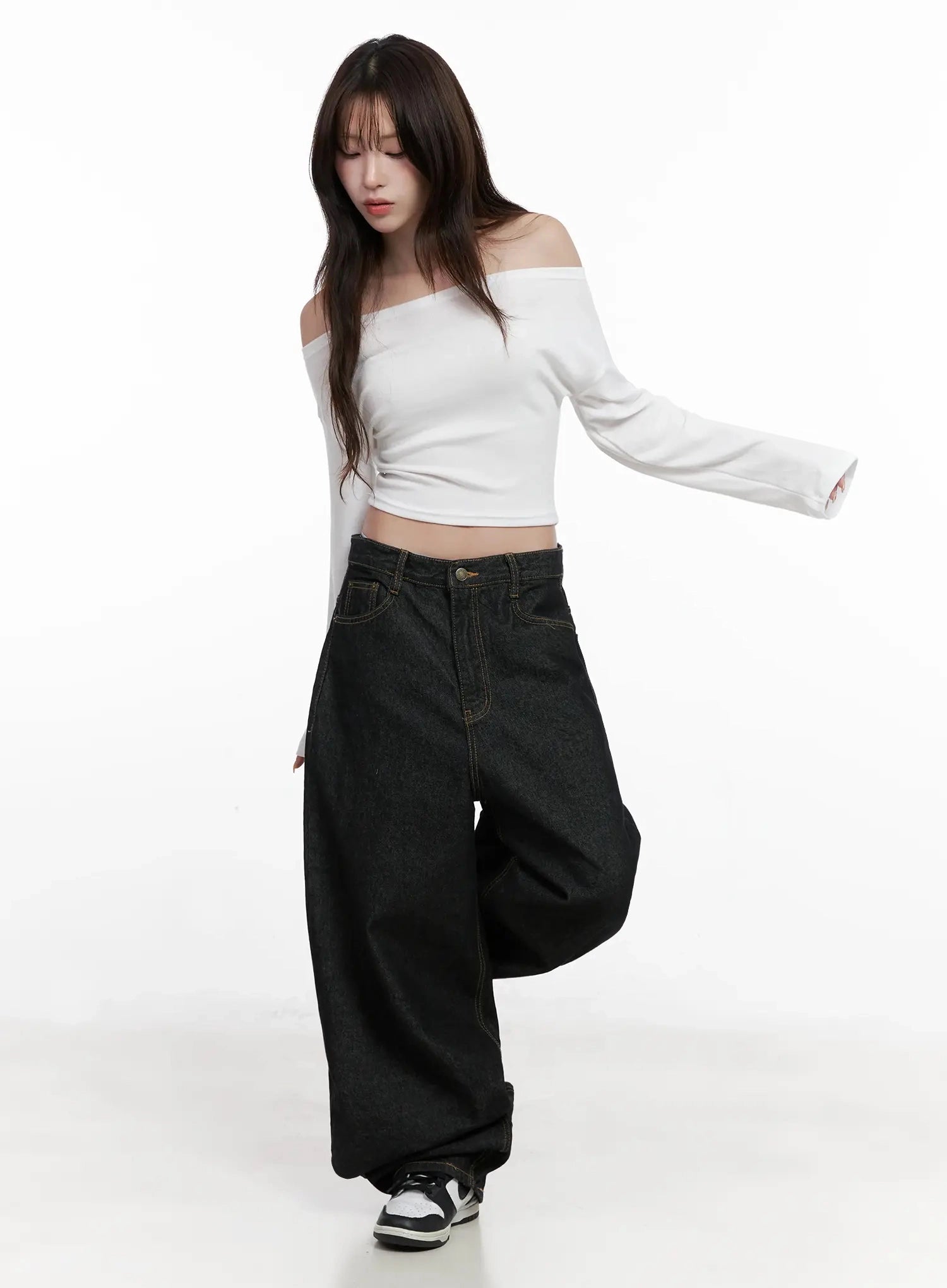 Halo Wide Leg Stitch Detail Jeans IN514 in black, full-body dynamic front pose on model, wide-leg cotton denim with gold topstitch, styled with white off-shoulder crop top and sneakers.