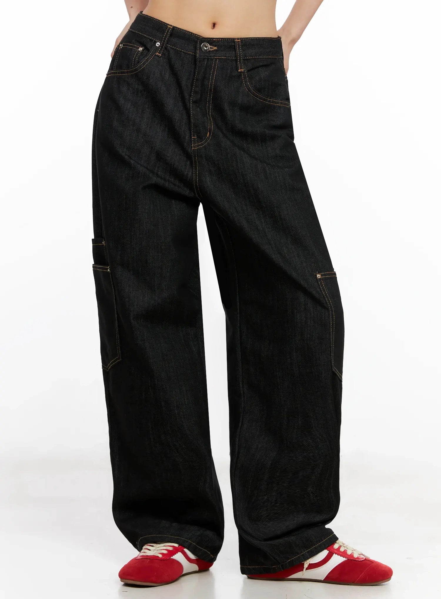 Dahee Wide-Leg Cargo Jeans IG508 in black, side-front view on headless model, showing front pockets, single side cargo pocket with flap, contrast topstitching, and wide-leg hem pooling over red sneakers.