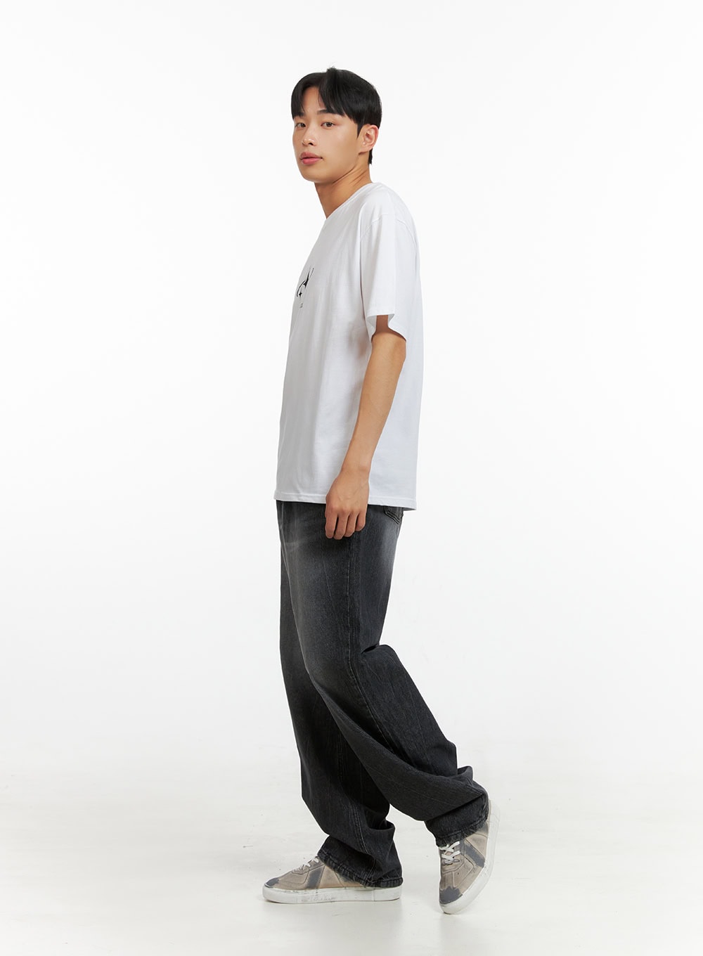 Men's Loose Fit Straight Jeans IU412 in washed black, side profile view on model mid-stride, loose straight leg with washed denim texture, paired with white tee and silver sneakers.