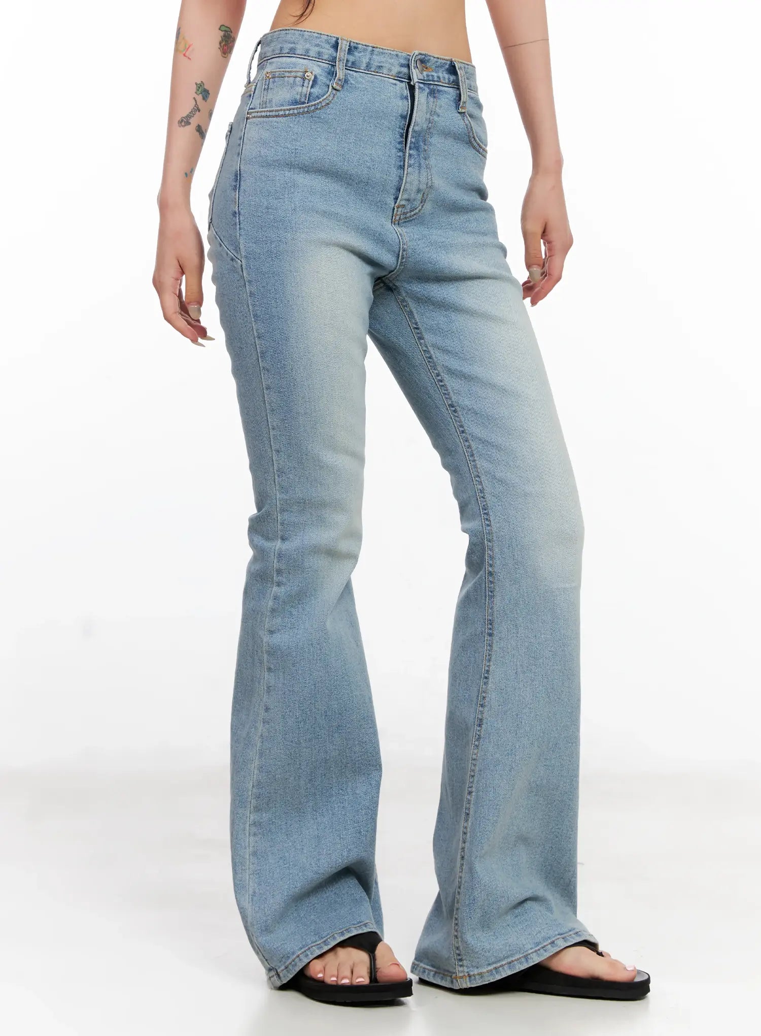 Byeol Washed Flare Denim Jeans CL525 in light blue, angled side view on model showing full-length slim flare silhouette, washed denim with faded thigh detail and front pockets.