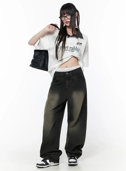 Oversized Collar Jersey CU519 in white, full-body front on model with knotted hem exposing midriff, sporty graphic jersey with dark contrast collar, paired with wide-leg dark jeans, lace waistband visible, black bag.