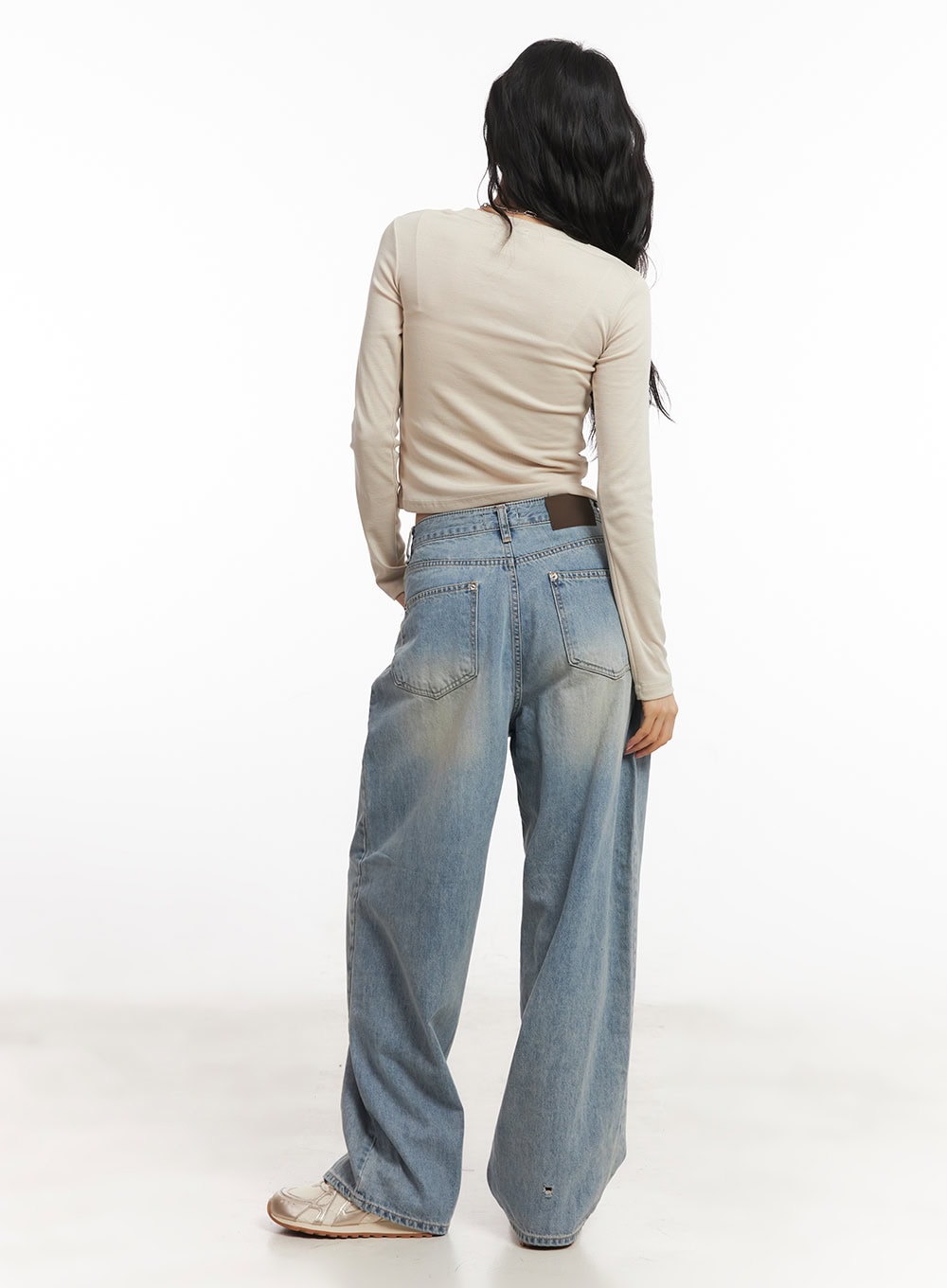 Devyn Wide-Leg Jeans CA503 in blue, full-body back view on model, washed wide-leg cotton denim with brown waistband patch, slight hem distressing, beige crop top.