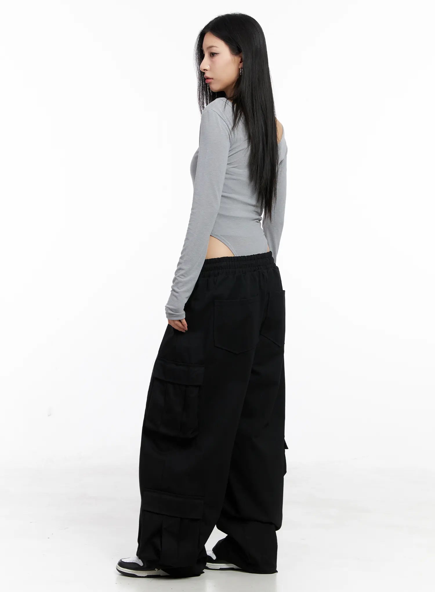 Wide Leg Cargo Pants CC1109 in black, back 3/4 view on model, back patch pockets visible, side cargo flaps, wide cotton leg, paired with grey crop top and sneakers.
