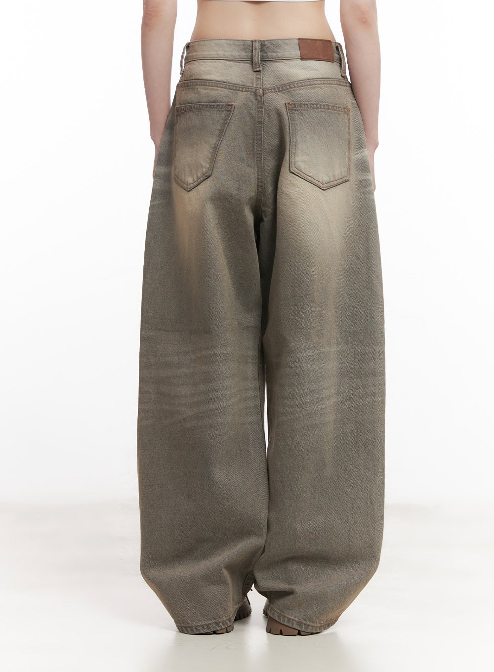 Joey Washed Wide-Leg Jeans CM528 in gray, back waist-down close-up on model, featuring dual back patch pockets, brown leather brand tab at waistband, and sun-bleached washed cotton denim detail.
