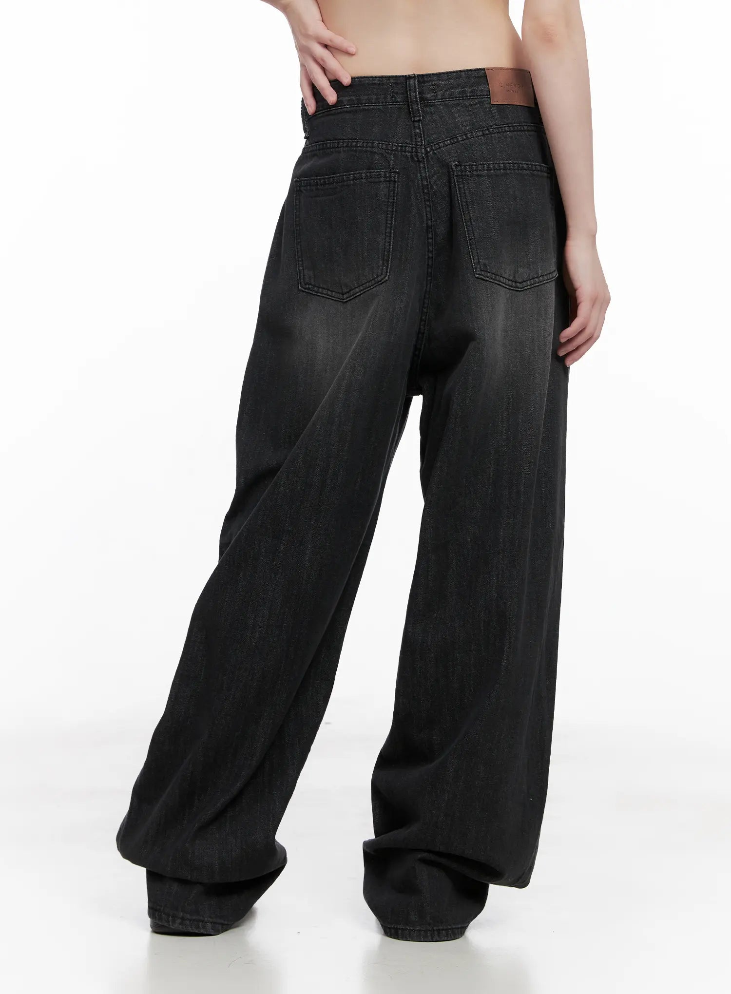 Elen Pintuck Baggy Jeans CG519 in black, back close-up on model, featuring dual back pockets, brown leather patch, and washed faded denim texture across wide-leg silhouette.