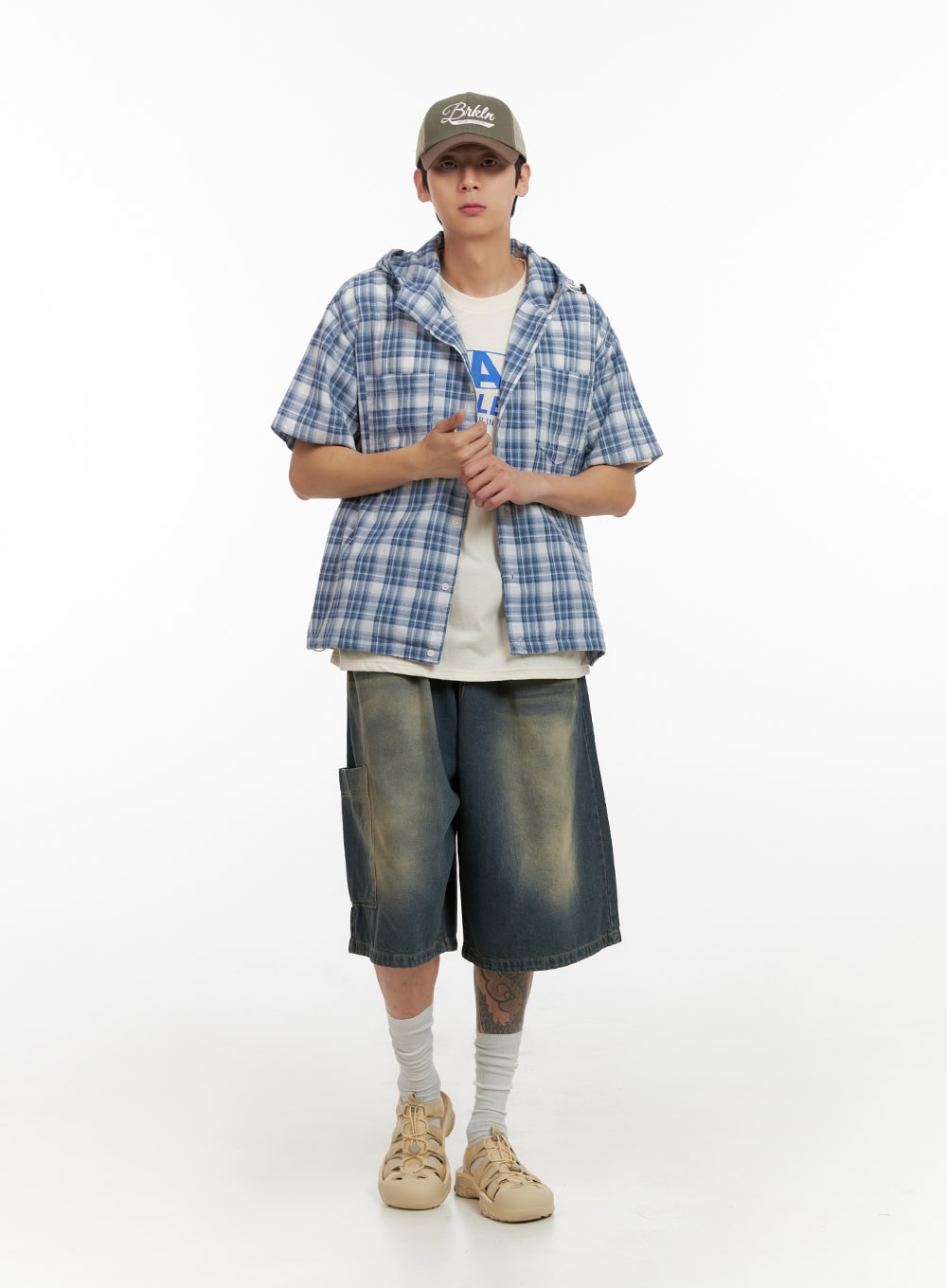 Men's Denim Washed Shorts (Blue) IL404 in blue, front full-body on model facing camera, wide-leg cut with heavy washed finish and cargo pockets, styled with plaid hooded overshirt.