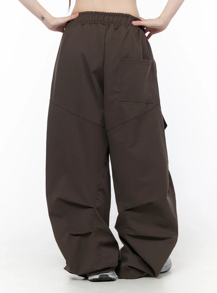 Wide Leg Pintuck Cargo Pants CU519 in dark brown, back product shot on model, back patch pocket, pintuck seam lines on wide ballooned leg, elastic waistband detail.