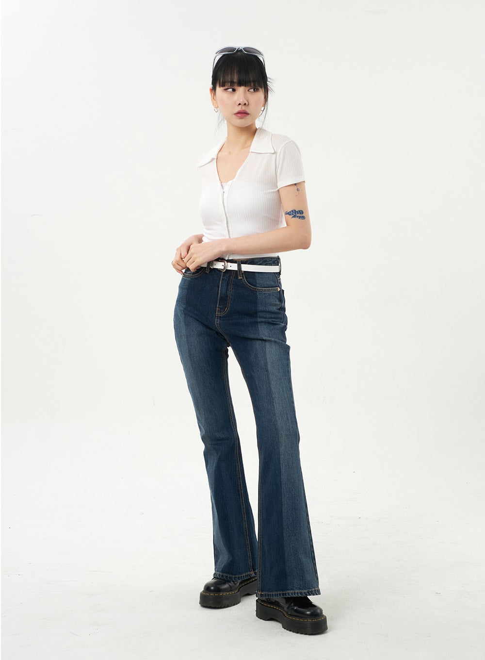 Dark Wash Bootcut Jeans CA328 in dark blue, front 3/4 view on model looking aside, slim high-rise fit with washed finish, white belt, subtle whiskering at thigh.