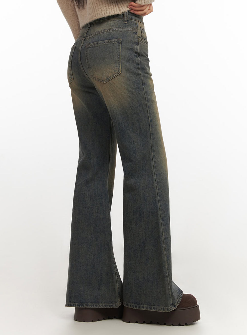 Kourtney Vintage Wash Flared Jeans IF510 in dark blue, side-rear three-quarter shot on model, showing back pocket detail and amber vintage-wash fade, flared hem brushing floor, no styling top.