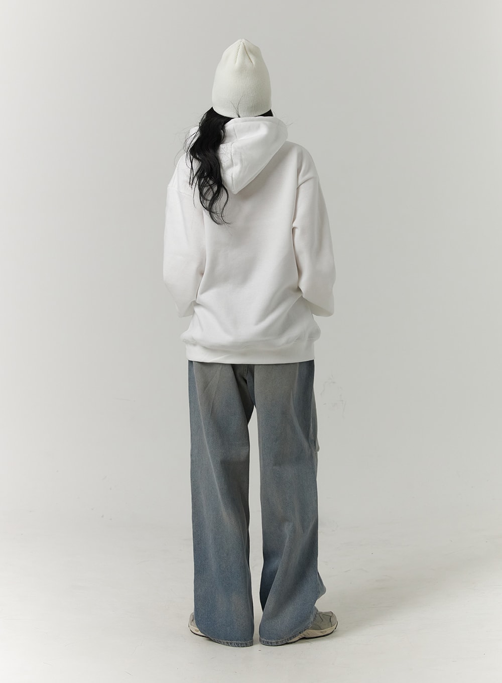 Pintuck Washed Denim Wide-Leg Jeans CJ418 in blue, back full-body view on model, wide-leg washed denim silhouette from behind, back pockets visible, styled with white hoodie and beanie.