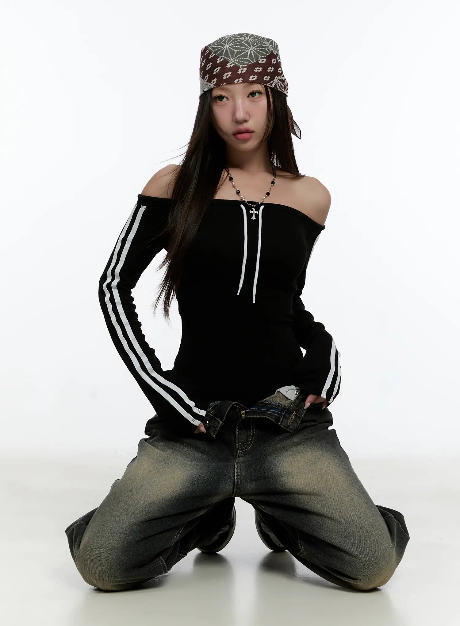 Emerie Washed Wide-Leg Baggy Jeans CS518 in dark blue, editorial kneeling pose on model, showing voluminous baggy silhouette and washed fading at thighs, styled with bandana hat and stripe top.