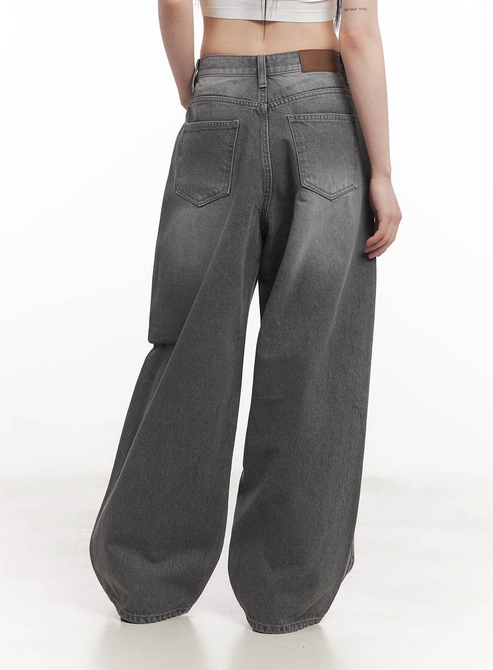 Venessa Washed Baggy Jeans CM528 in dark gray, back waist close-up on model, showing dual back pockets, brown leather patch label, and washed denim texture.