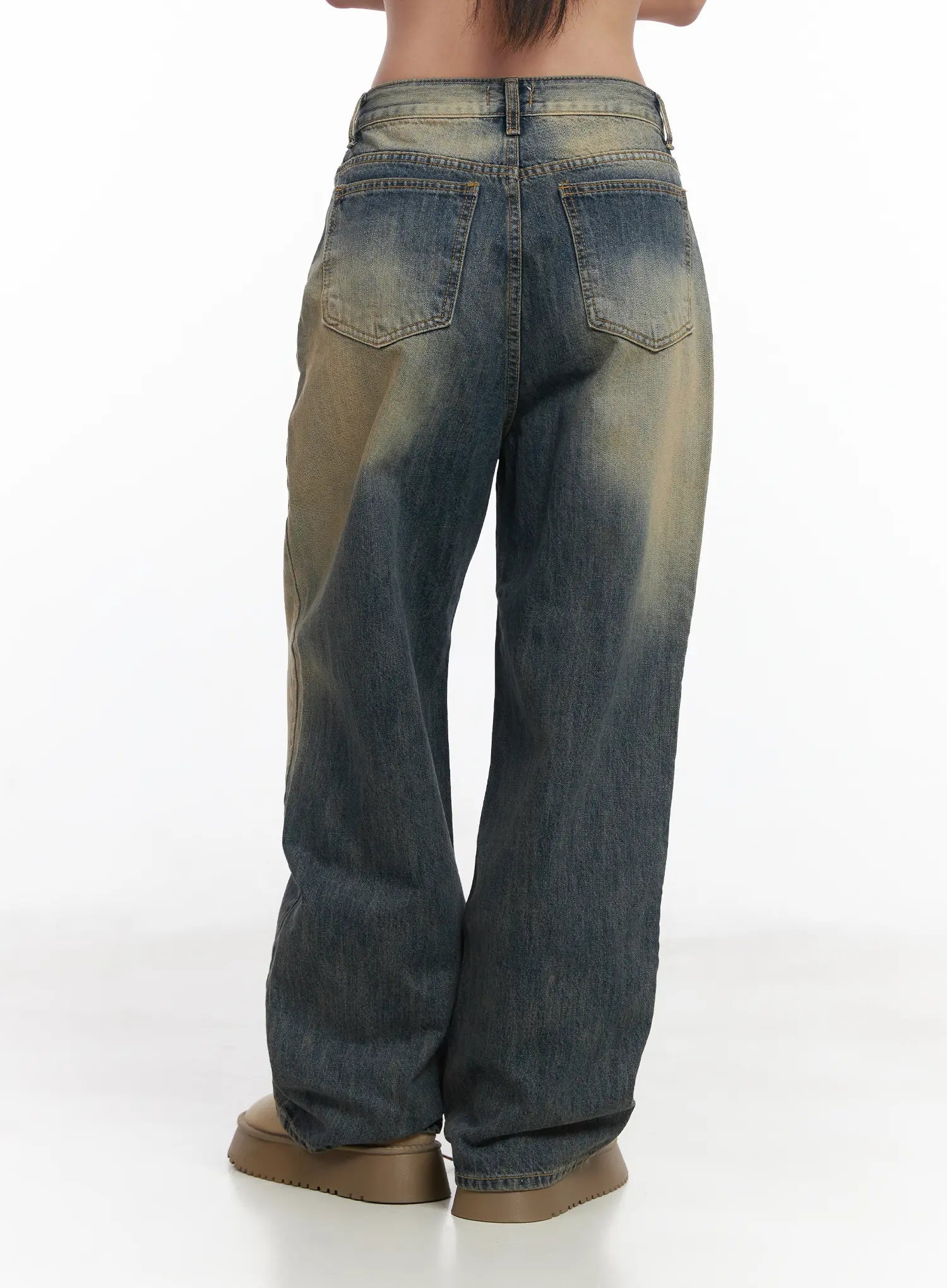 Wide Washed Jeans CS06 in vintage blue, back mid-length shot on model, wide-leg cotton denim showing dual back pockets with contrast stitching and heavy sandy-yellow wash fade at hips.