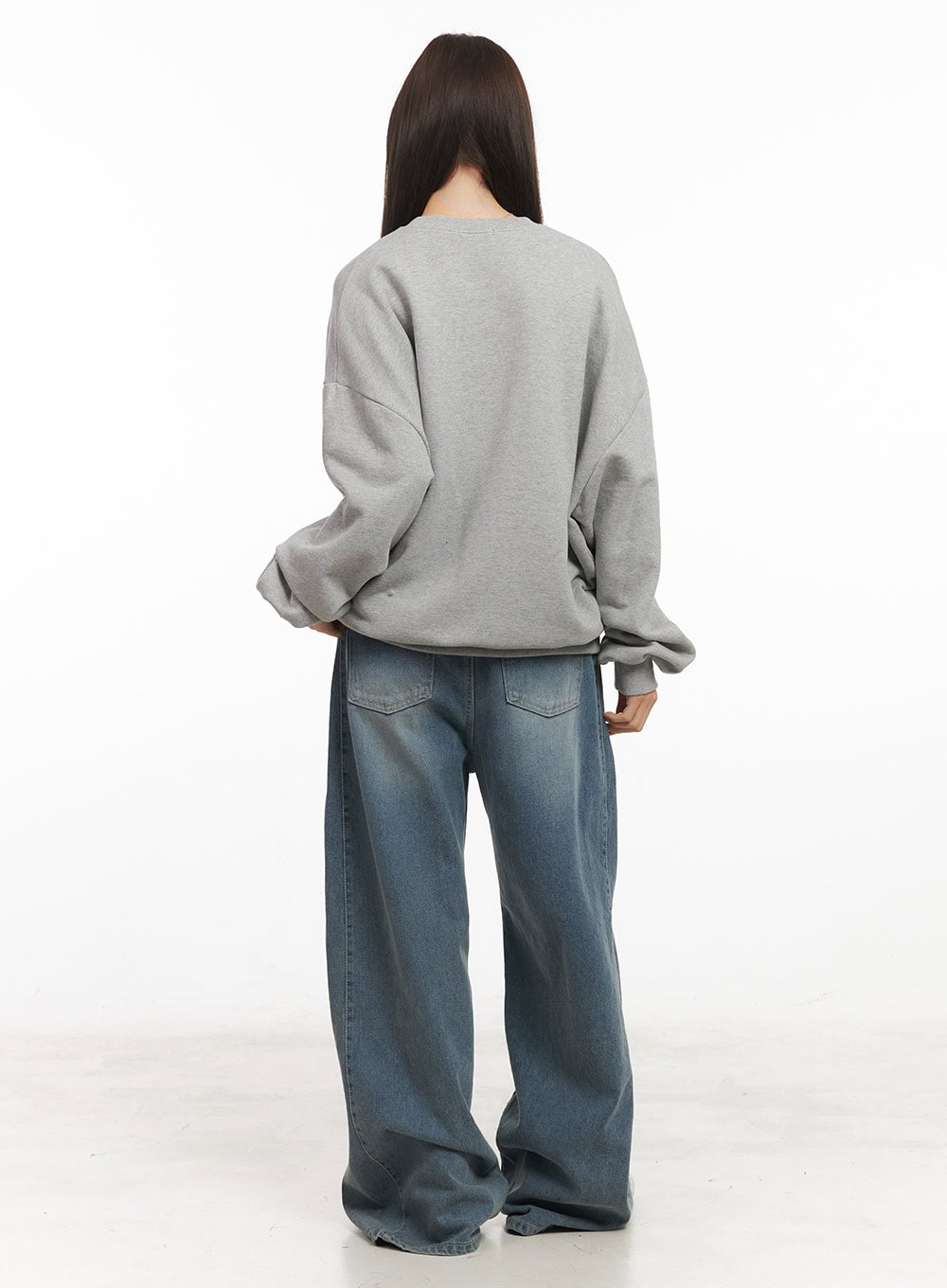 Amber Pintuck Wide-Leg Jeans CM511 in blue, back full-body shot on model, washed denim with back patch pockets, wide-leg hem pooling, styled with grey sweatshirt.